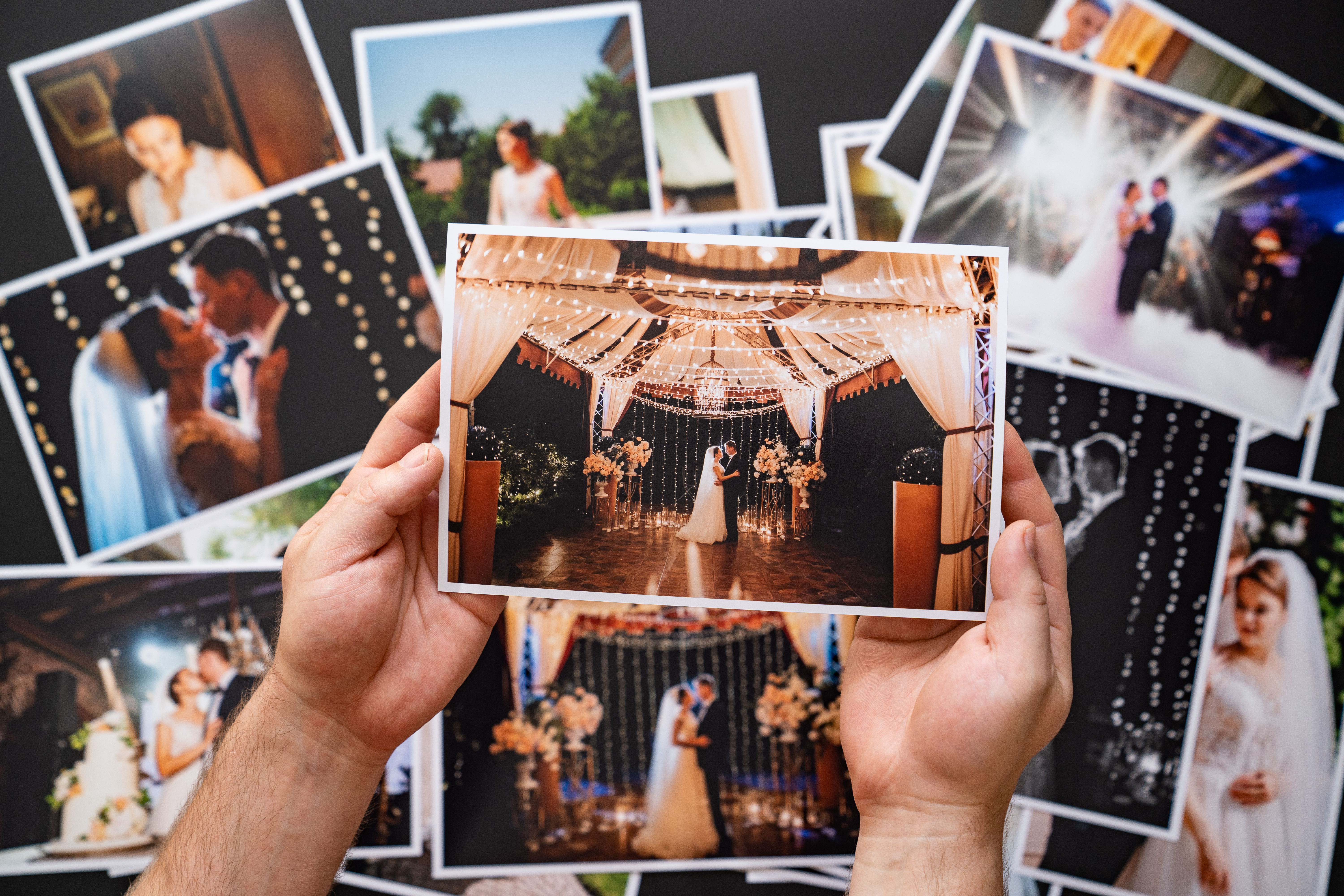 Hands lay out a printed copy of the wedding photos | Source: Shutterstock