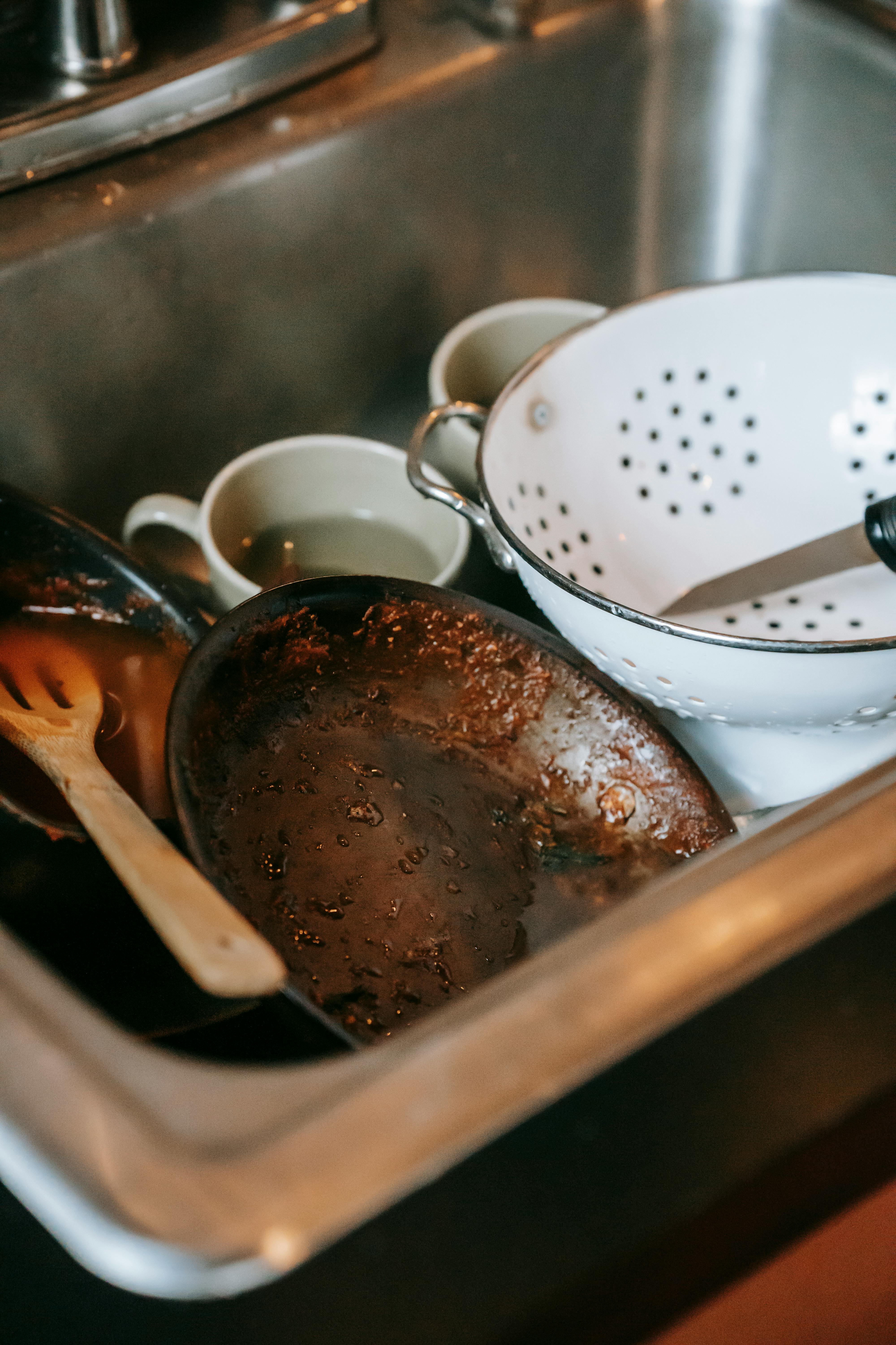 Dirty dishes piled in a kitchen sink | Source: Pexels