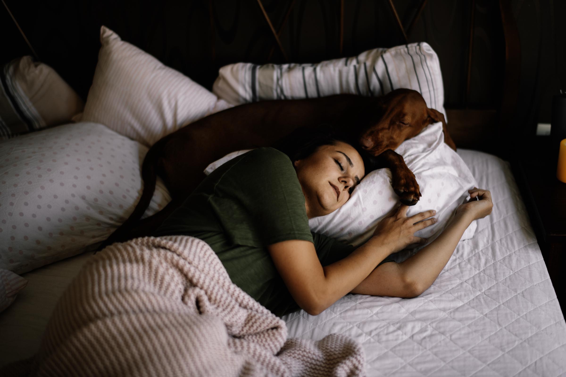 A woman and her dog taking a nap together | Source: Getty Images