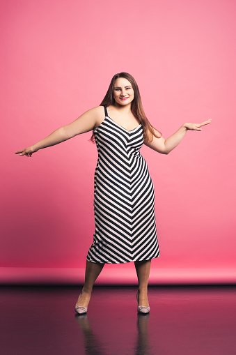 Une femme de taille grande en robe à rayures. | Photo : Getty Images 