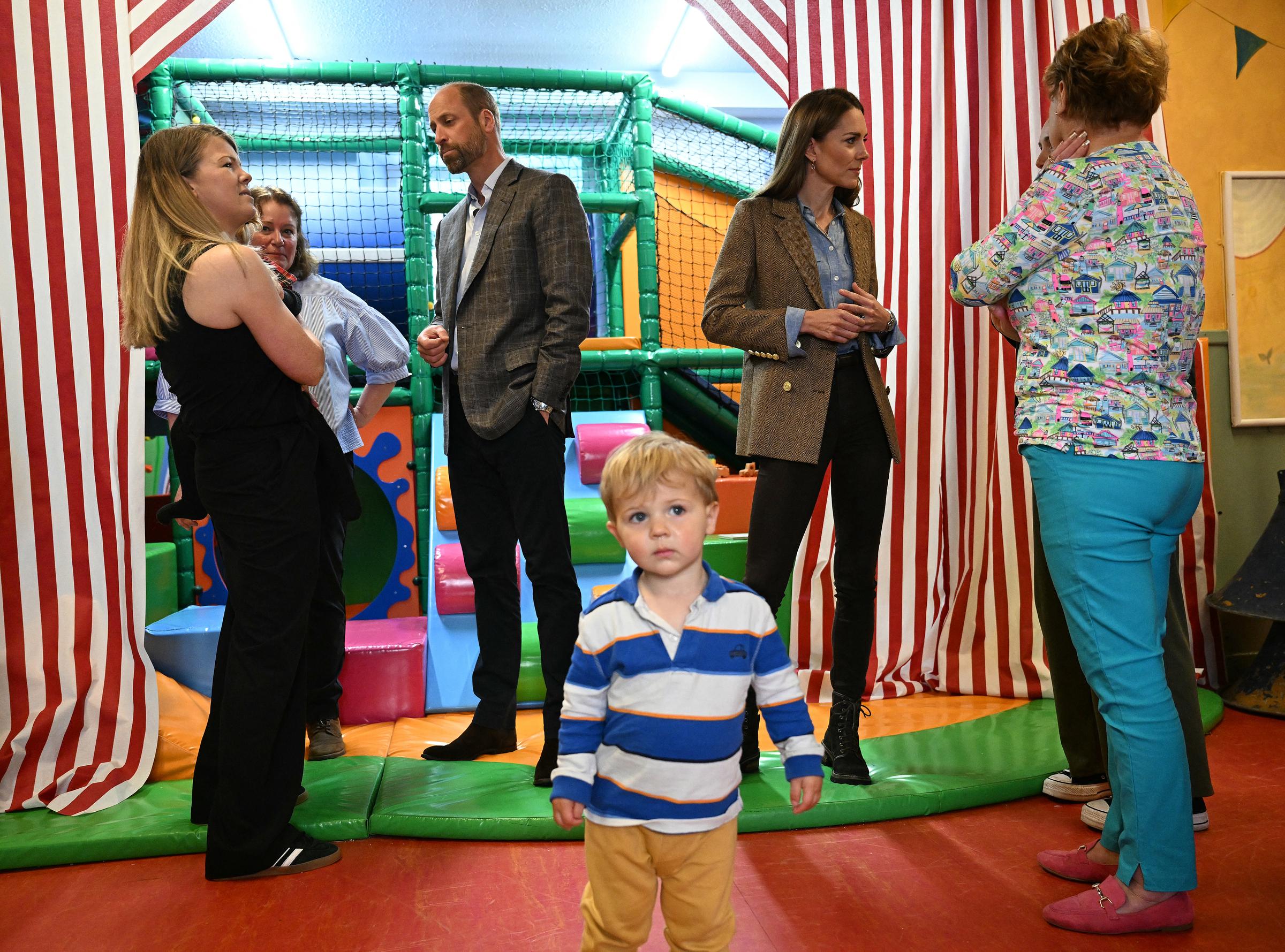 Inside Aros Hall's soft play zone, William and Catherine converse with parents and staff while children play nearby. The couple's interest in family-focused community spaces was a key part of their Tobermory stop.