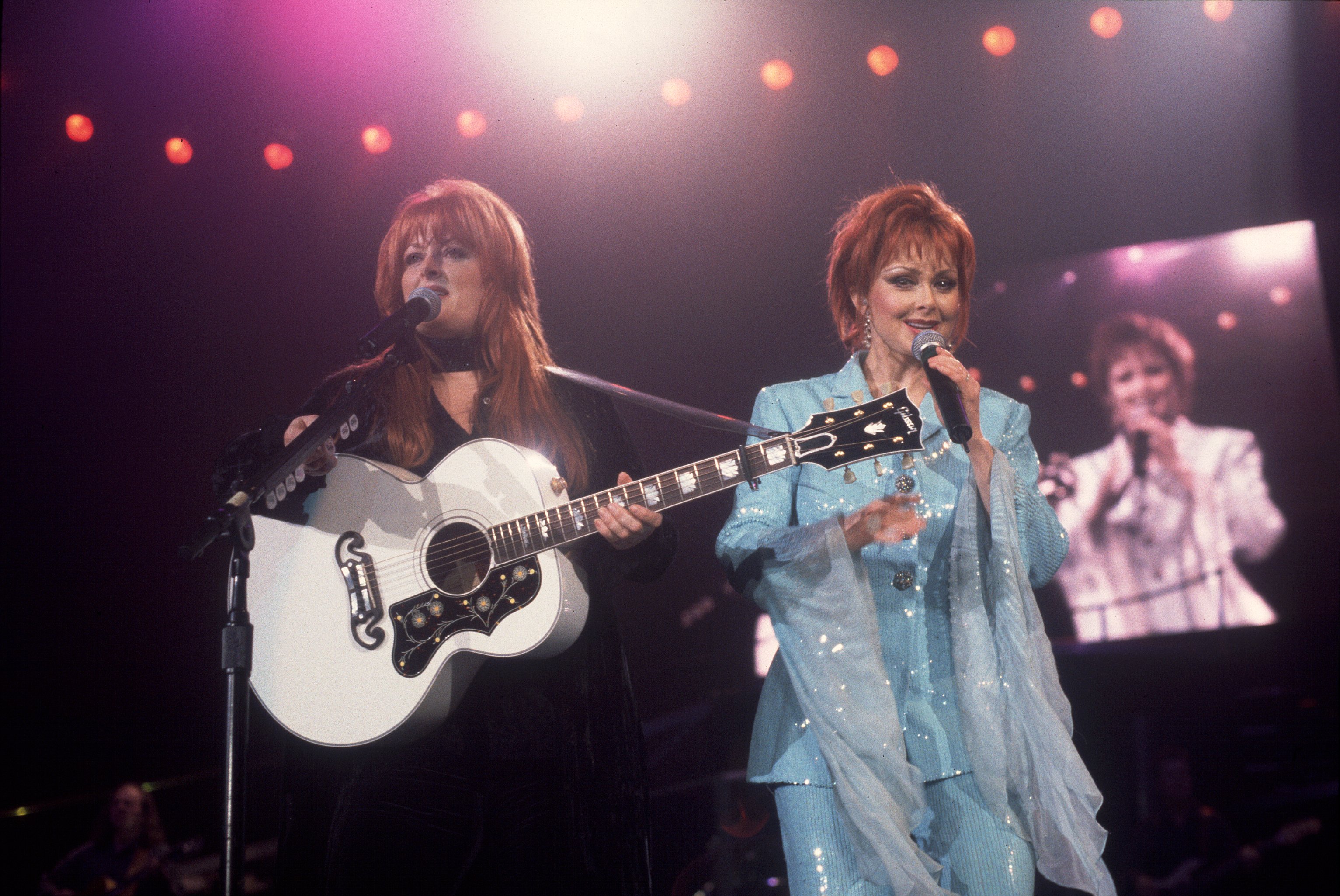 Country müzik ikilisi the Judds, Wynonna Judd ve annesi Naomi ile birlikte 1 Şubat 1991'de Rosemont, Illinois'deki Rosemont Horizon'da sahne alıyor.  Kaynak: Getty Images