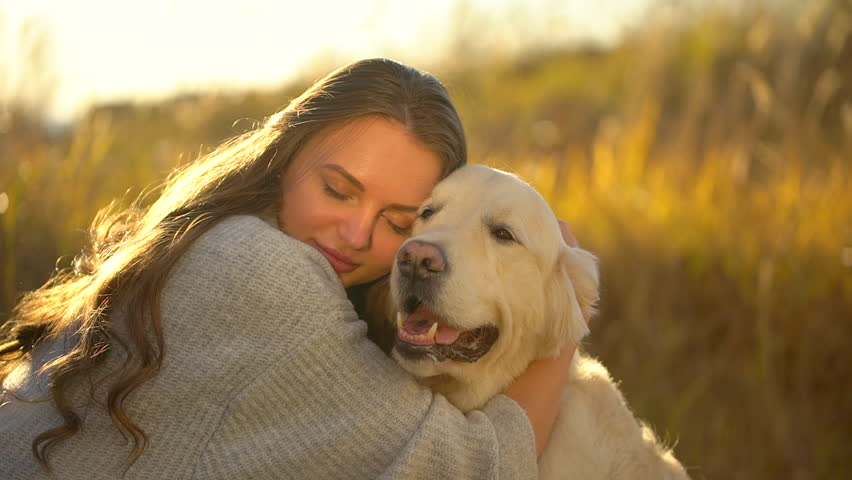 Pretty young woman hugging her dog | Photo: Shutterstock