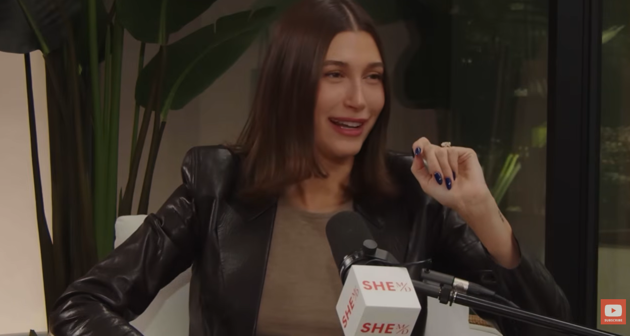 Hailey Bieber reacts while discussing her pregnancy experience during the "She MD" podcast episode | Source: YouTube/SHEMDPodcast