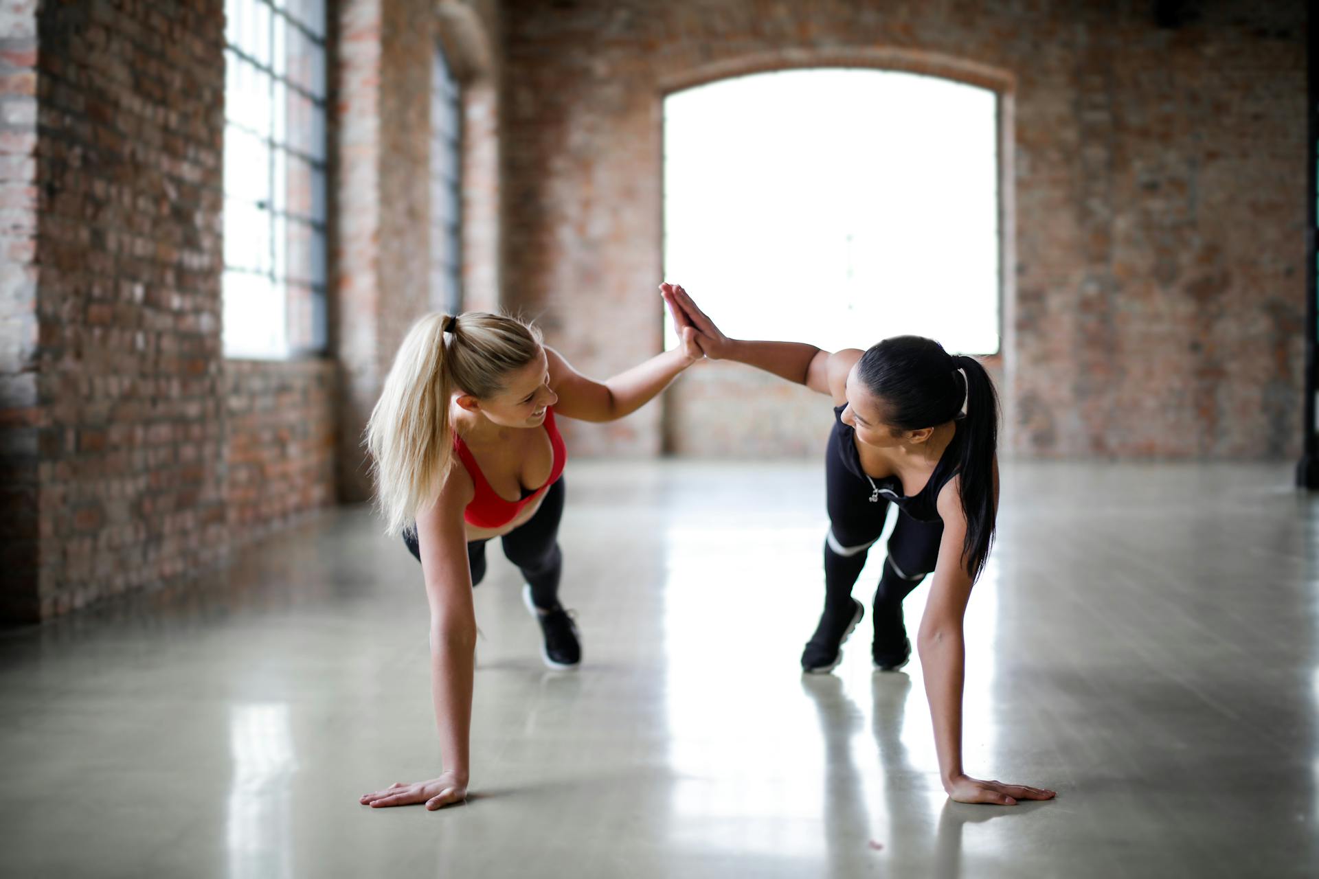 Two women doing a high-five while working out together | Source: Pexels