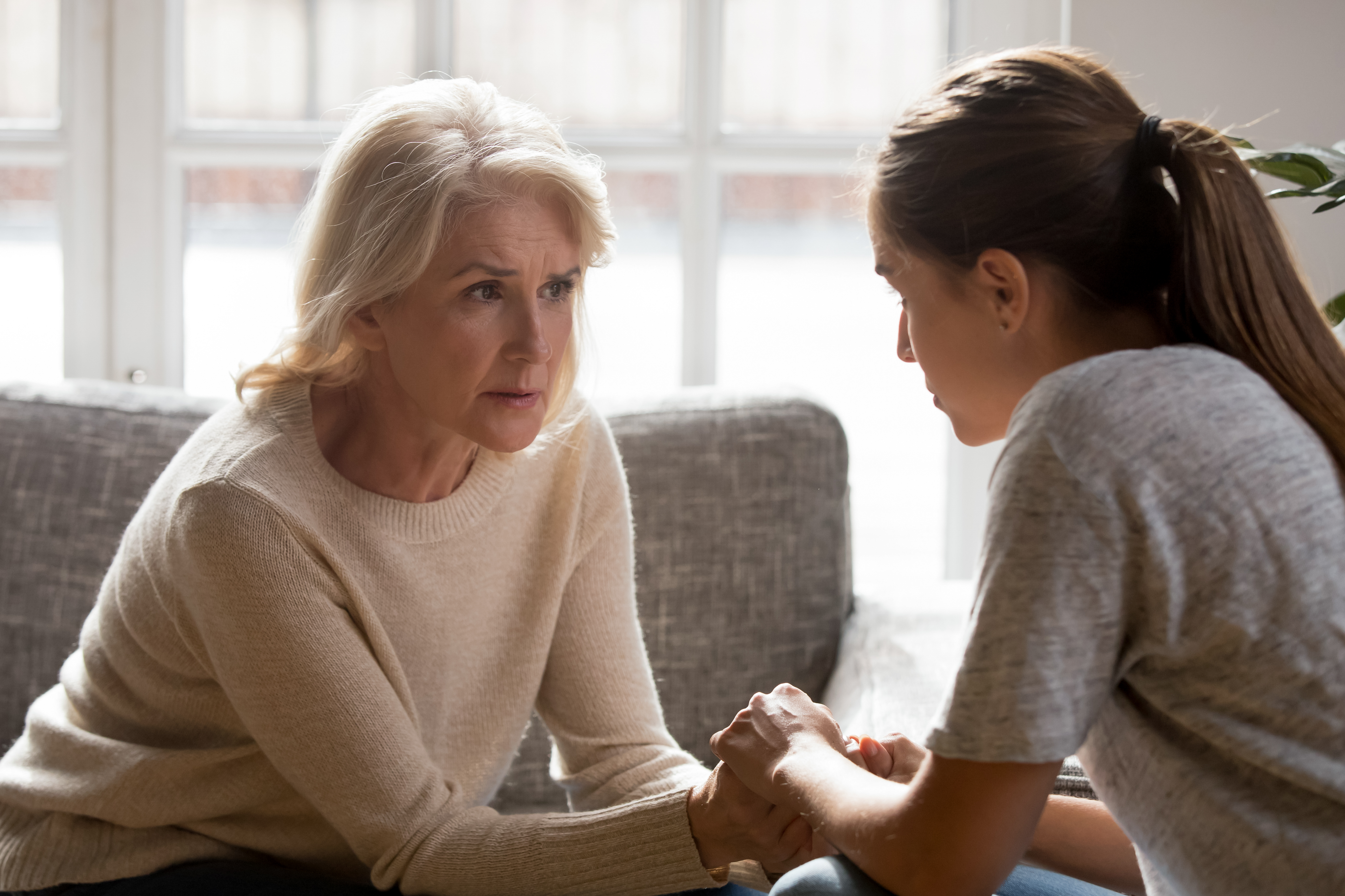 A senior woman talking seriously to a young woman | Source: Shutterstock