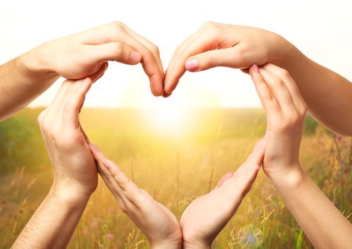 Heart shaped by hands with nature background. | Source: Shutterstock.