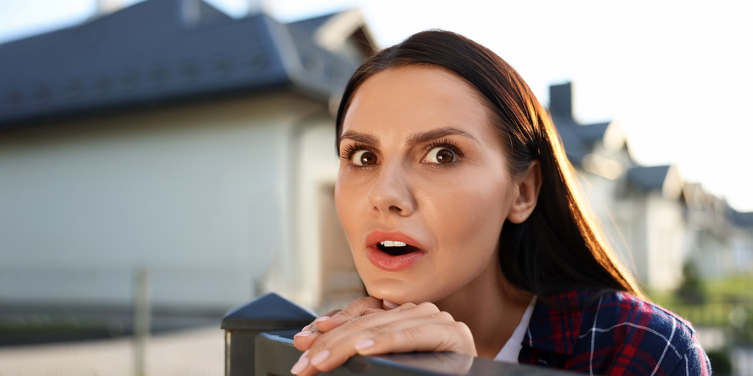 A shocked woman staring into her neighbor's yard | Source: Shutterstock