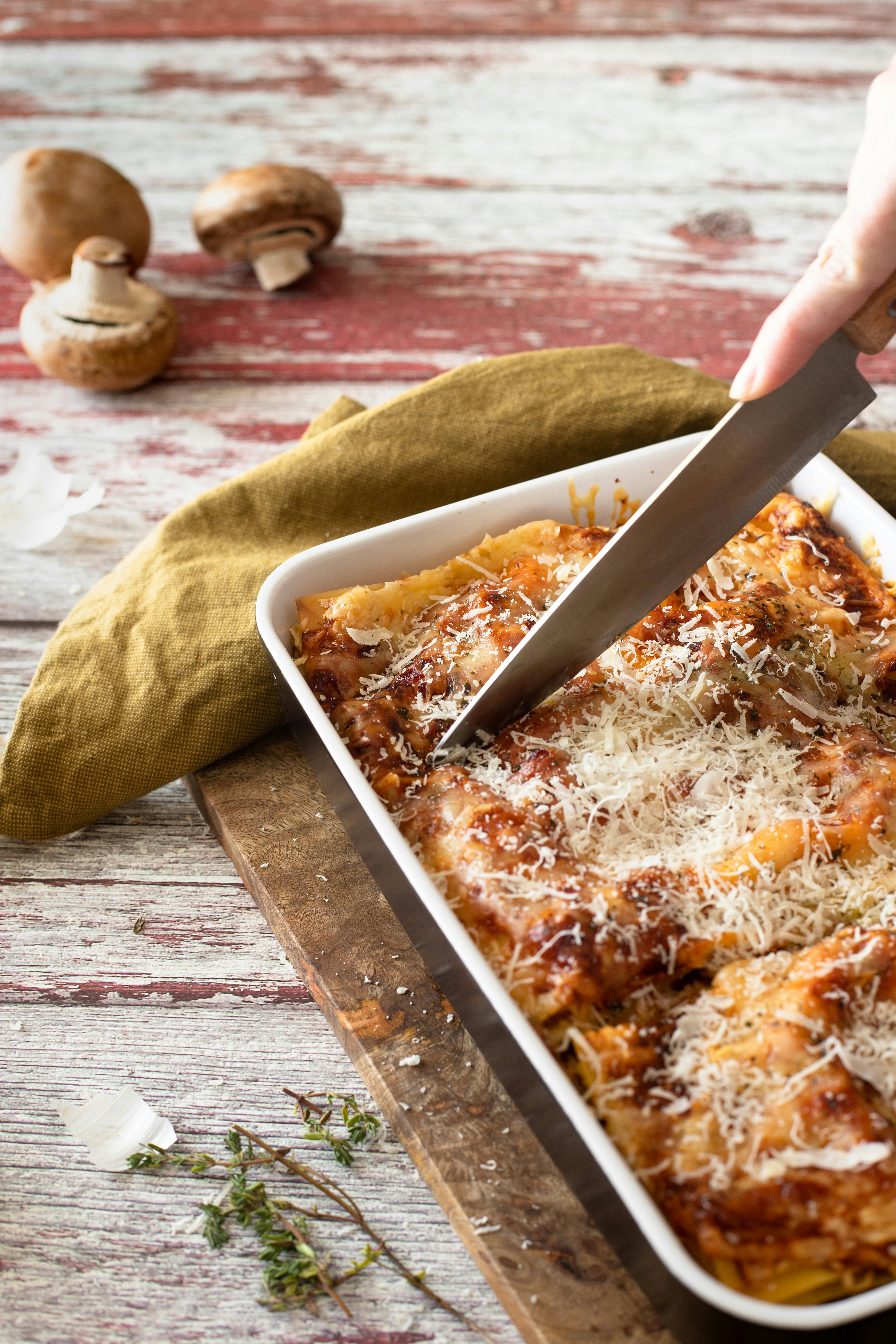 Slicing of lasagna on a ceramic tray | Source: Pexels