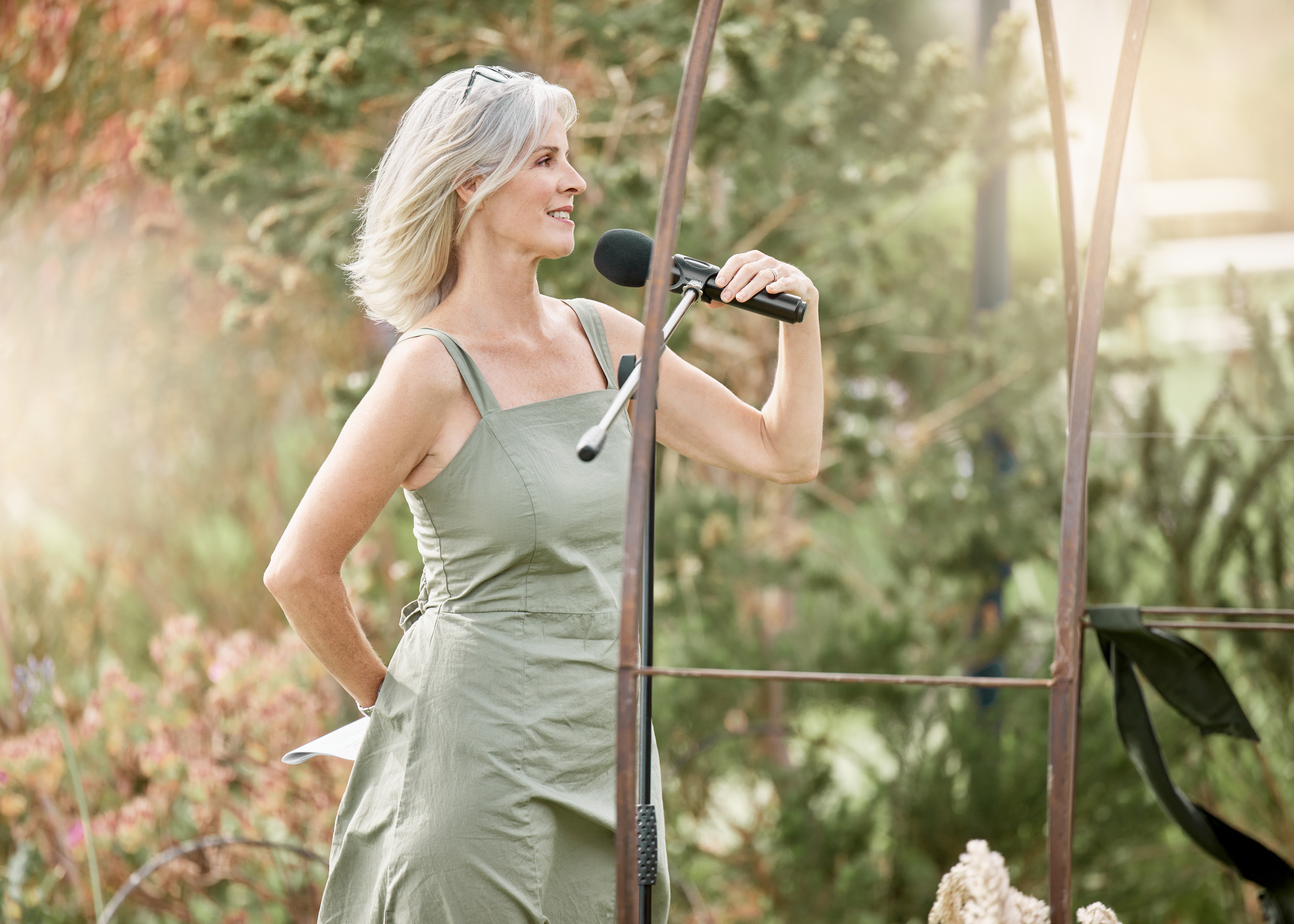 Woman, wedding and pastor speaker about to start a speech at an outdoor event. Elderly senior person that is family, friend or religious figure holding a microphone speaking and talking in nature | Source: Getty Images