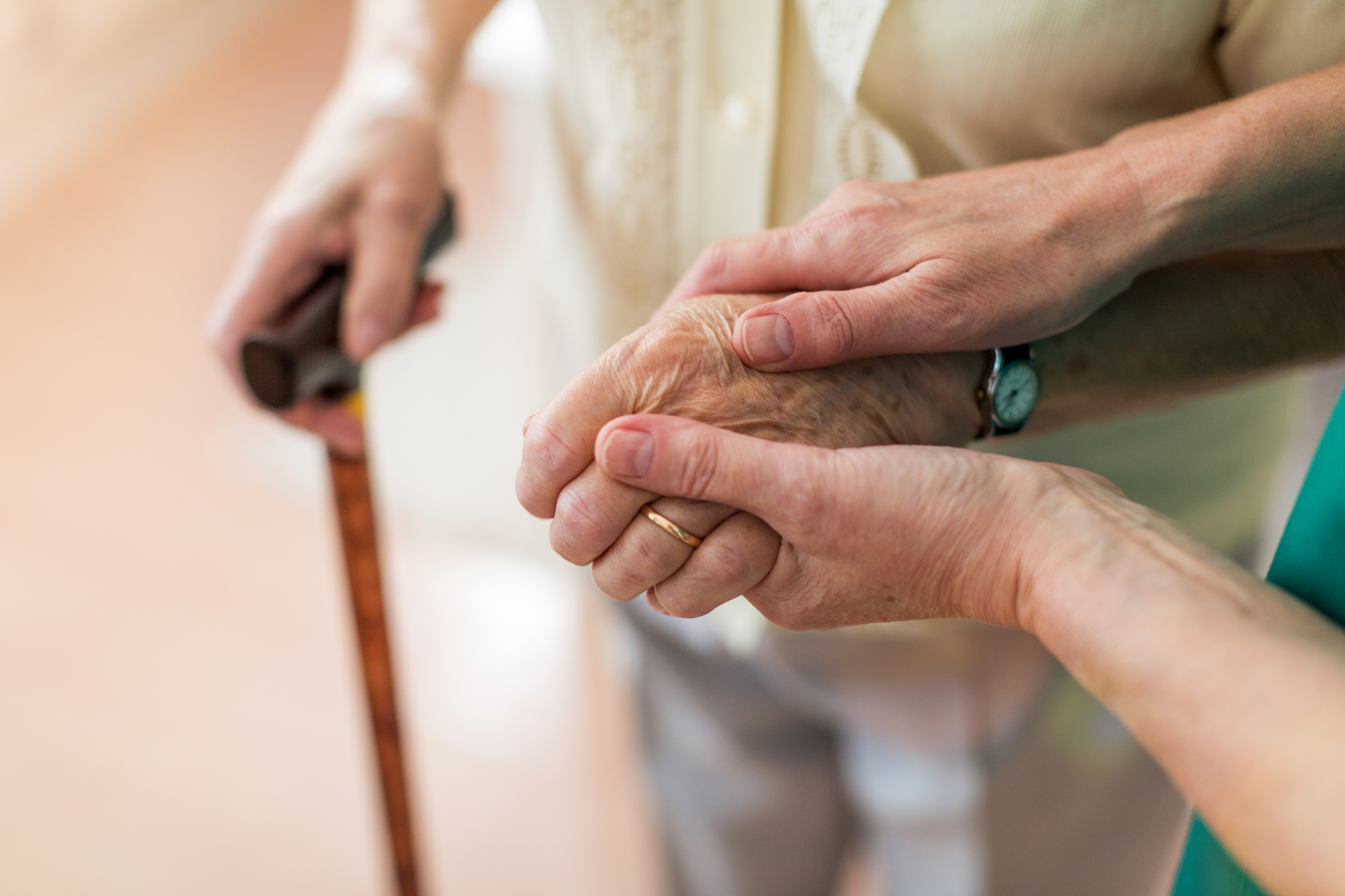 Nurse consoling her elderly patient by holding her hands. | Source: Shutterstock