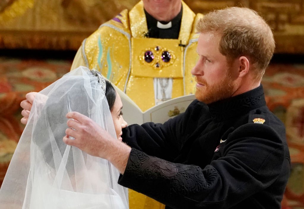 Prince Harry lifting Meghan Markle's veil during their wedding ceremony in 2018 at St George's Chapel at Windsor Castle, Windsor, England. | Photo: Getty Images