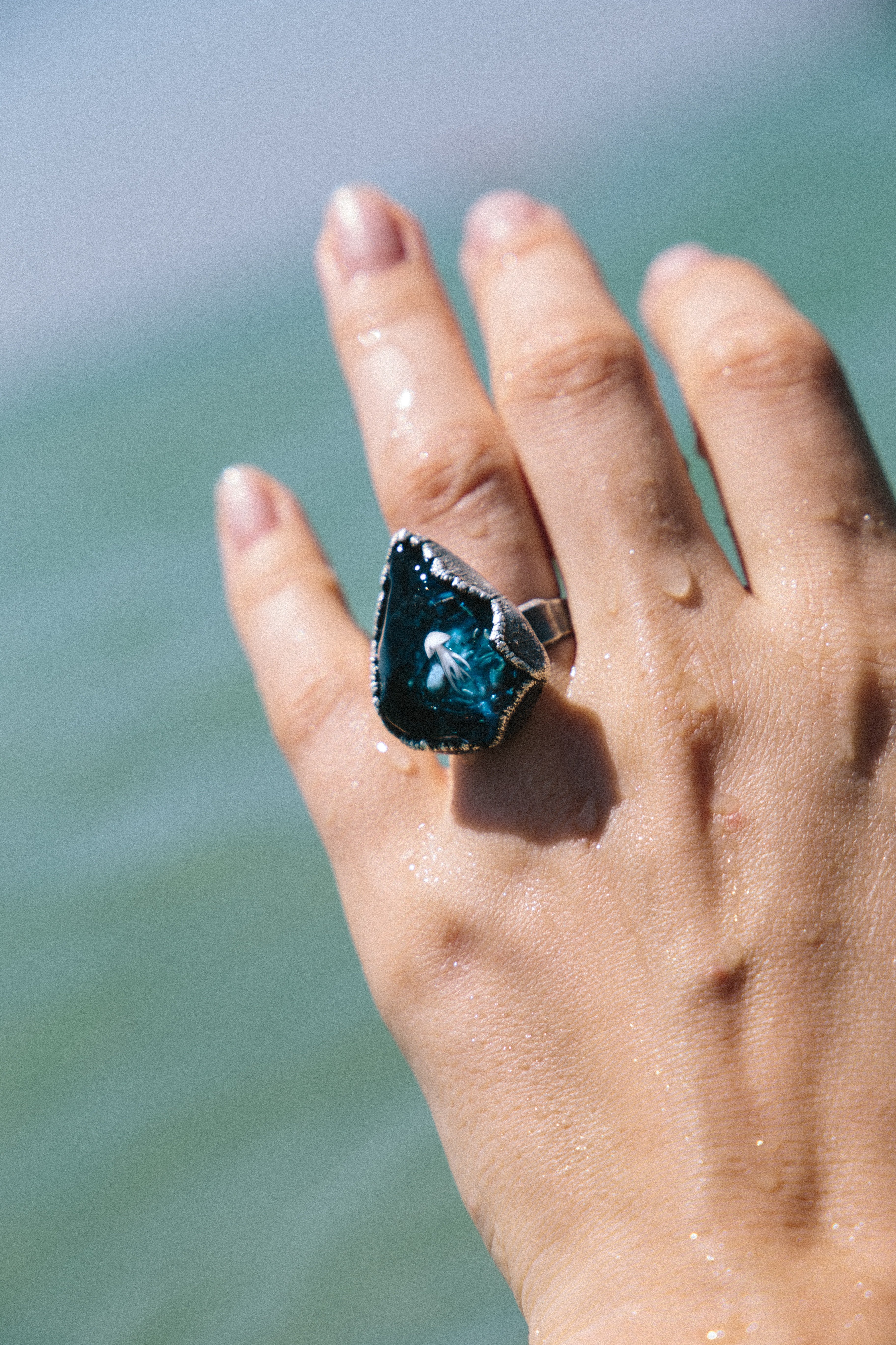 A woman wears a large blue gem on her ring finger | Photo: Unsplash/Klara Kulikova 