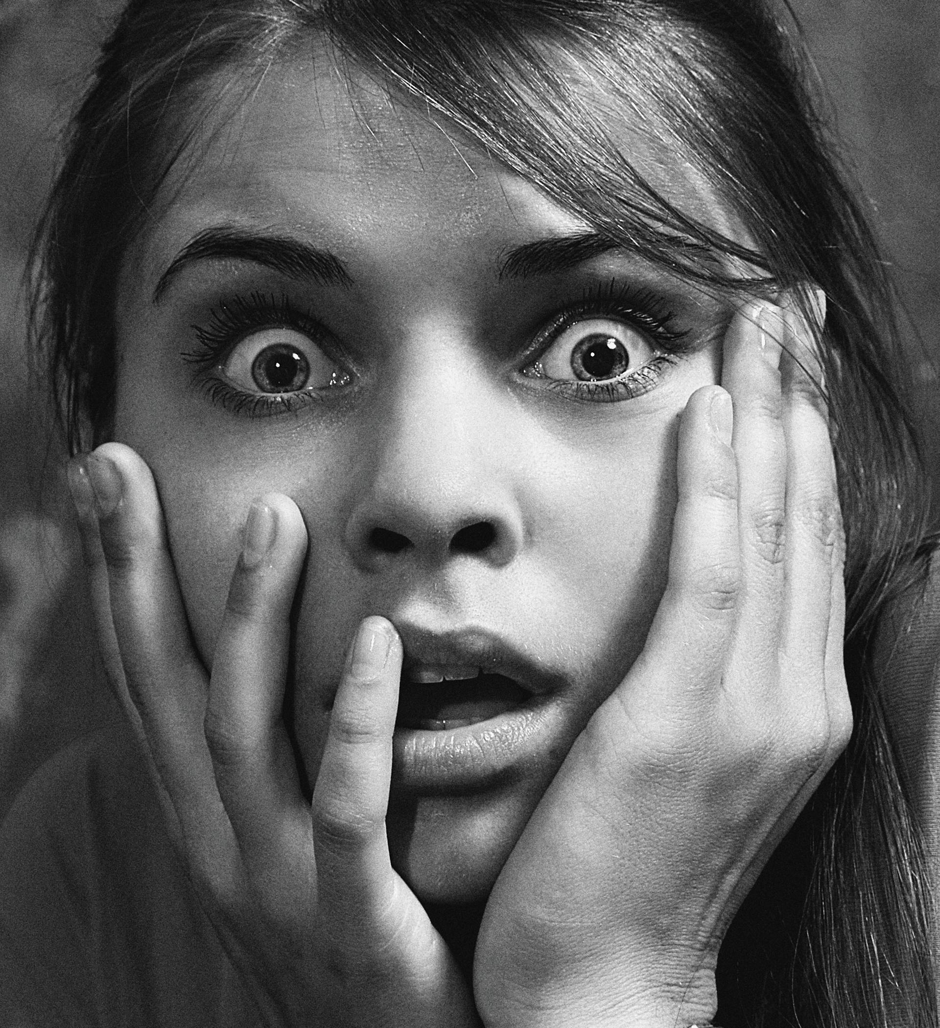 Grayscale close-up portrait of a shocked woman | Source: Pexels