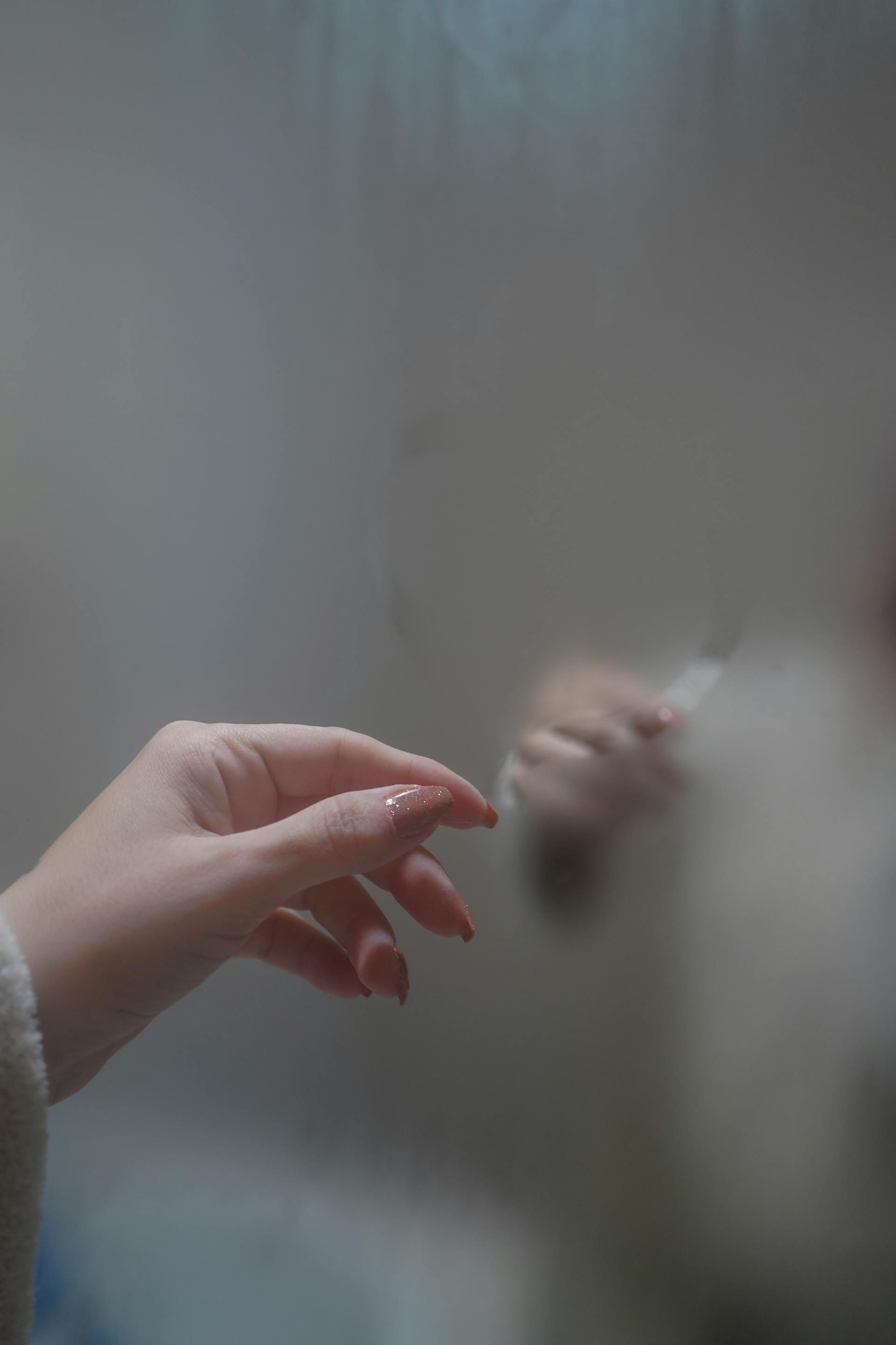 A woman's hand on a foggy mirror surface | Source: Pexels