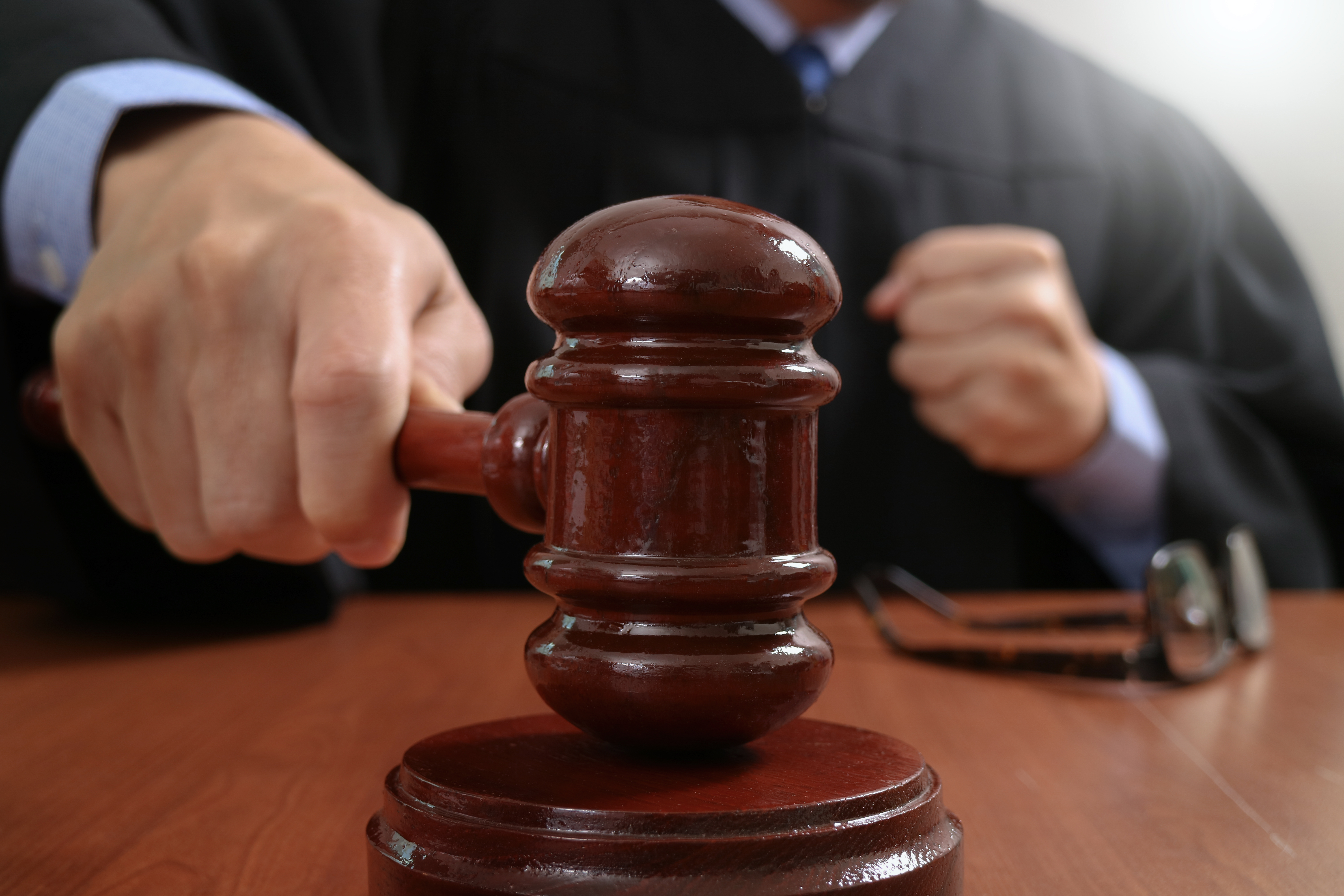 A male judge in a courtroom is pictured hitting his gavel | Source: Shutterstock