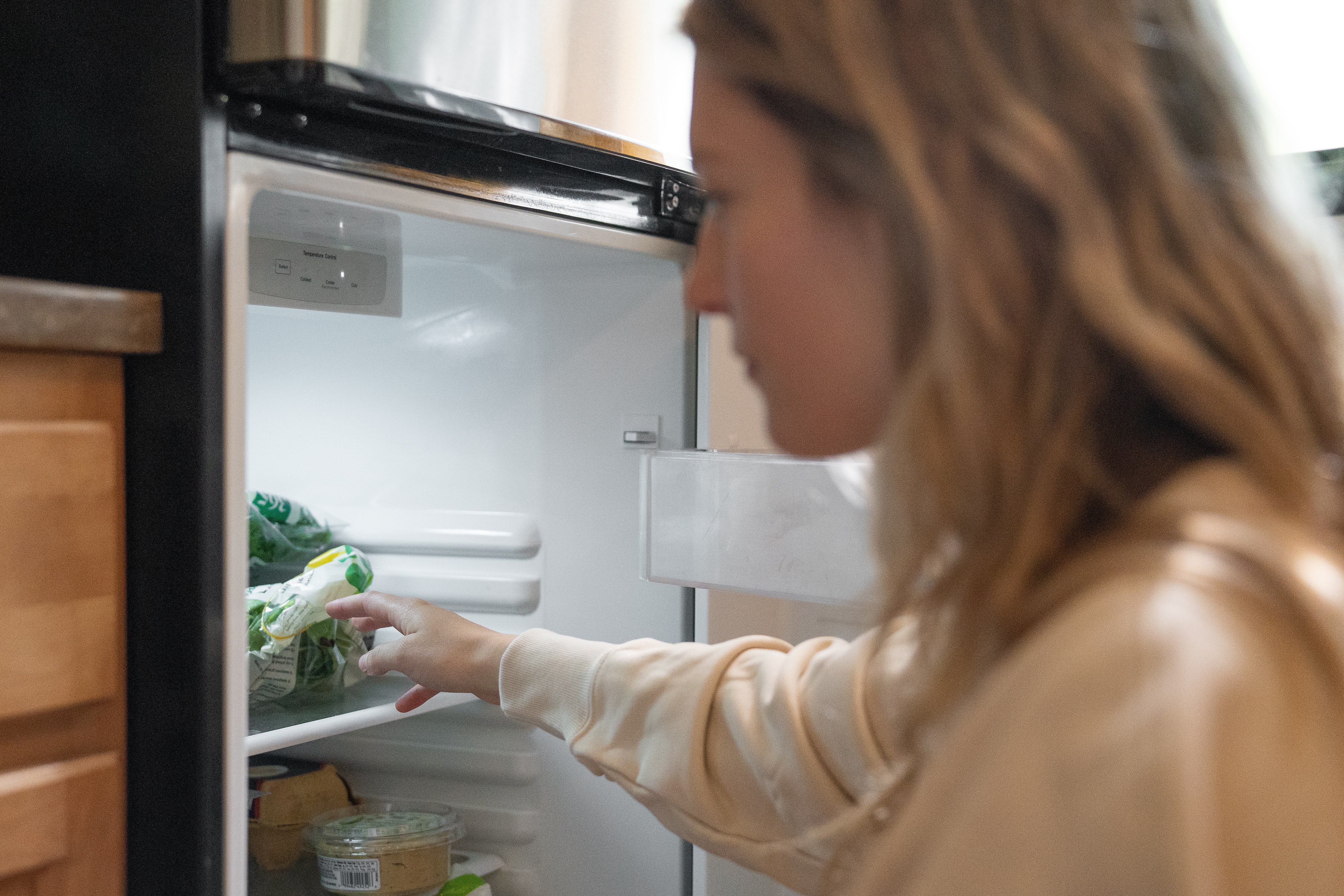 OP senses a strange presence behind her while cleaning the fridge | Photo: Pexels