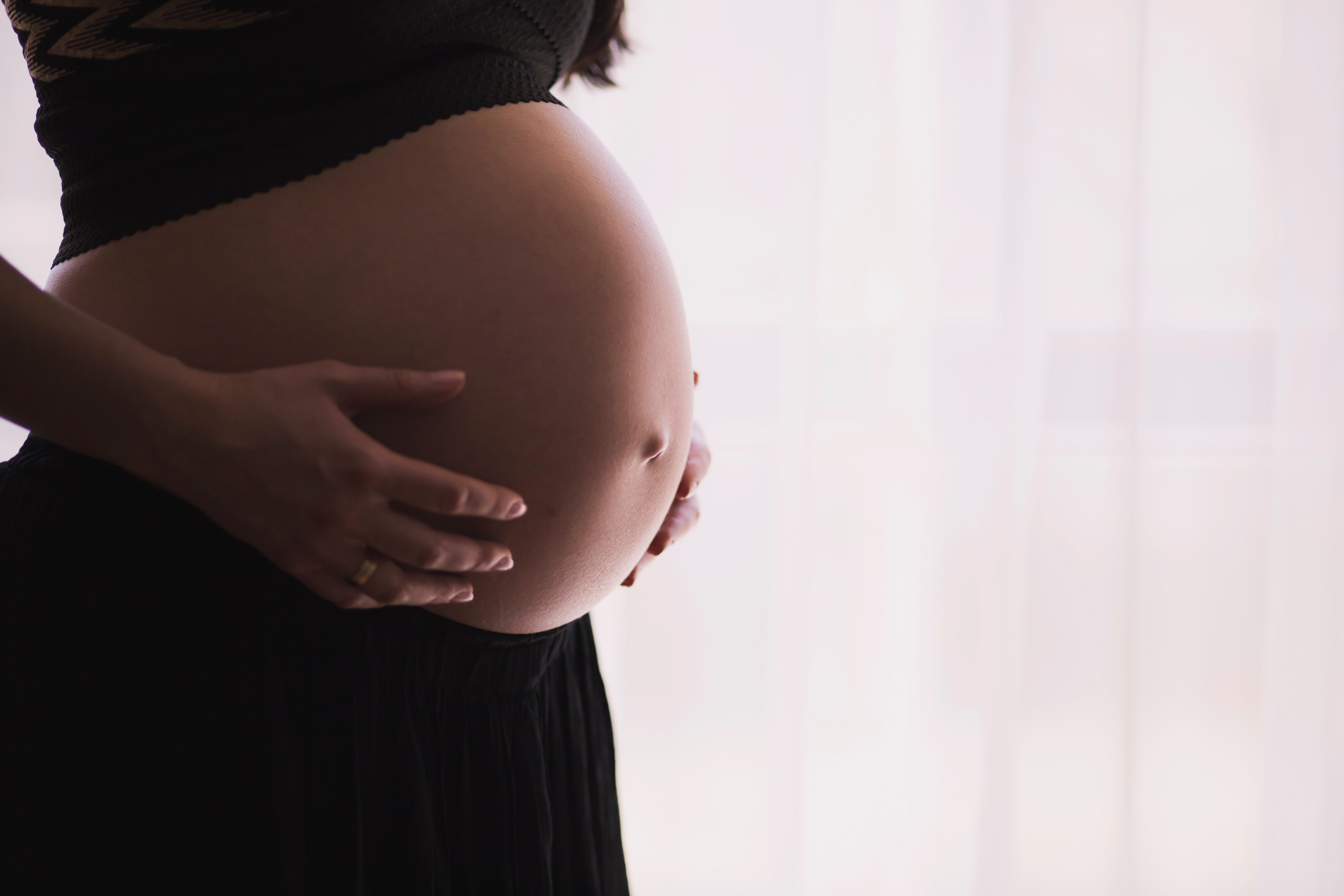 Image of a pregnant woman holding her belly. | Source: Pexels