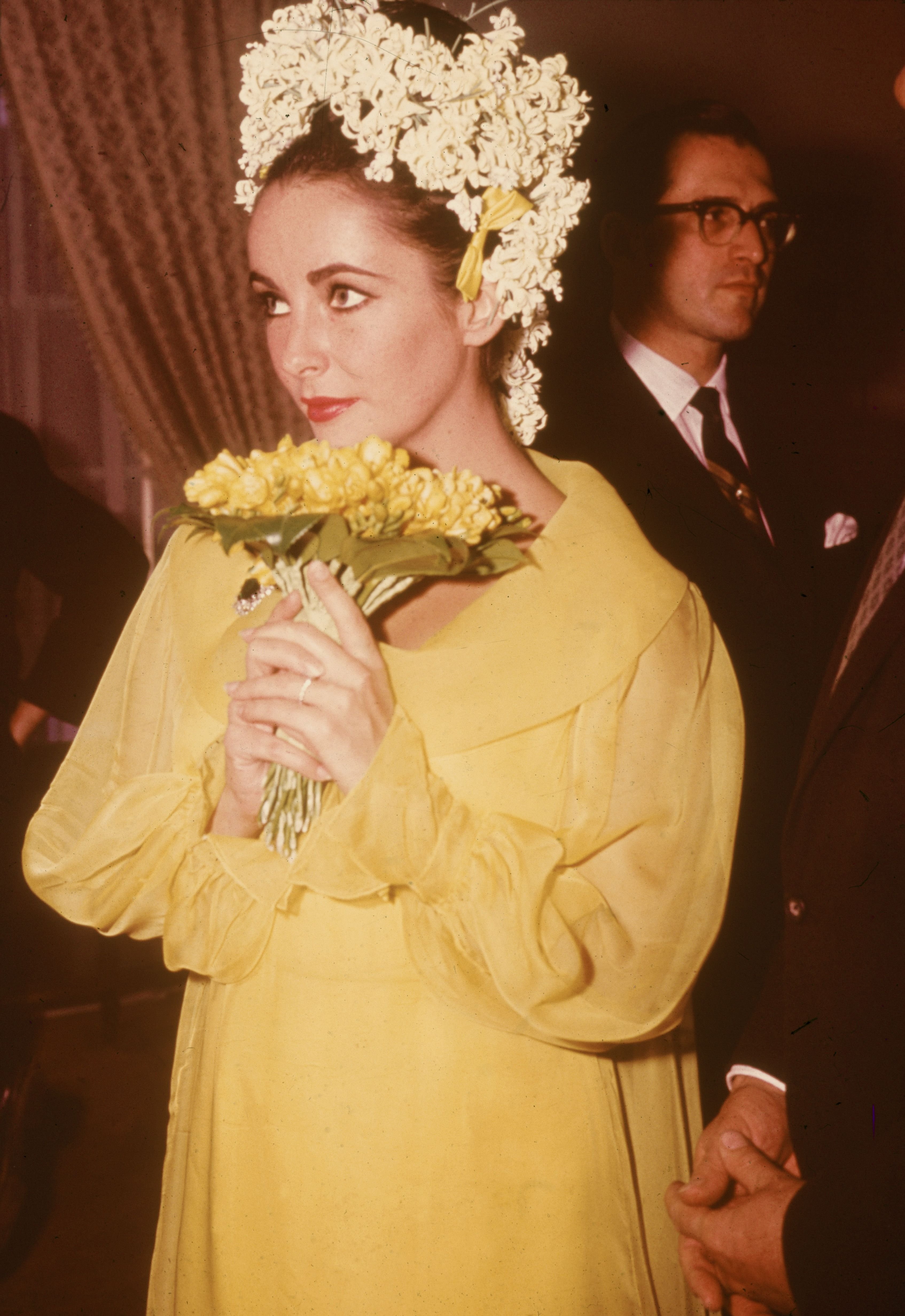 Elizabeth Taylor holds a bouquet of flowers at her wedding to actor Richard Burton on March 15, 1964.| Photo: Hulton Archive/Getty Images