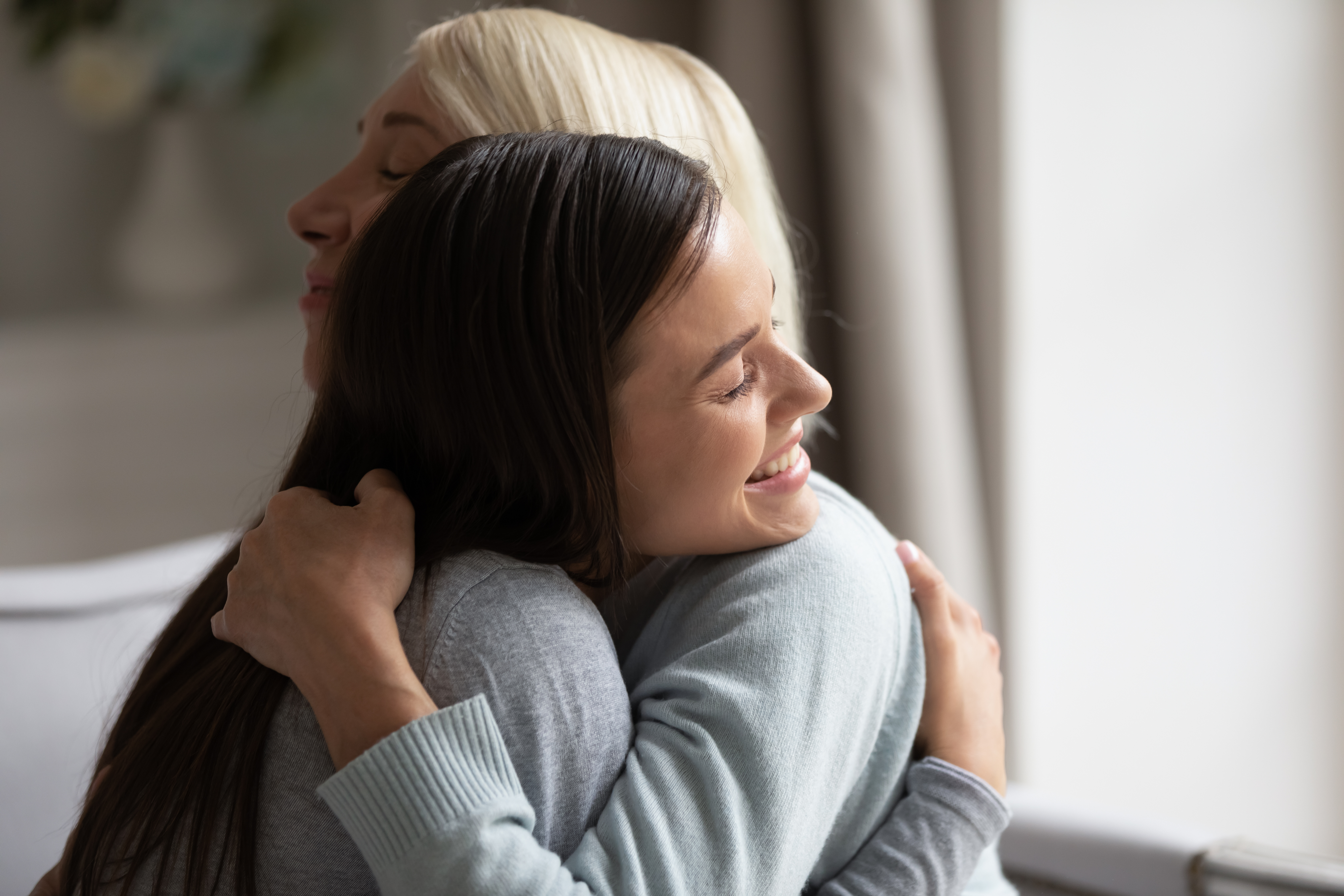 A grown up daughter hugging elderly mother | Source: Shutterstock
