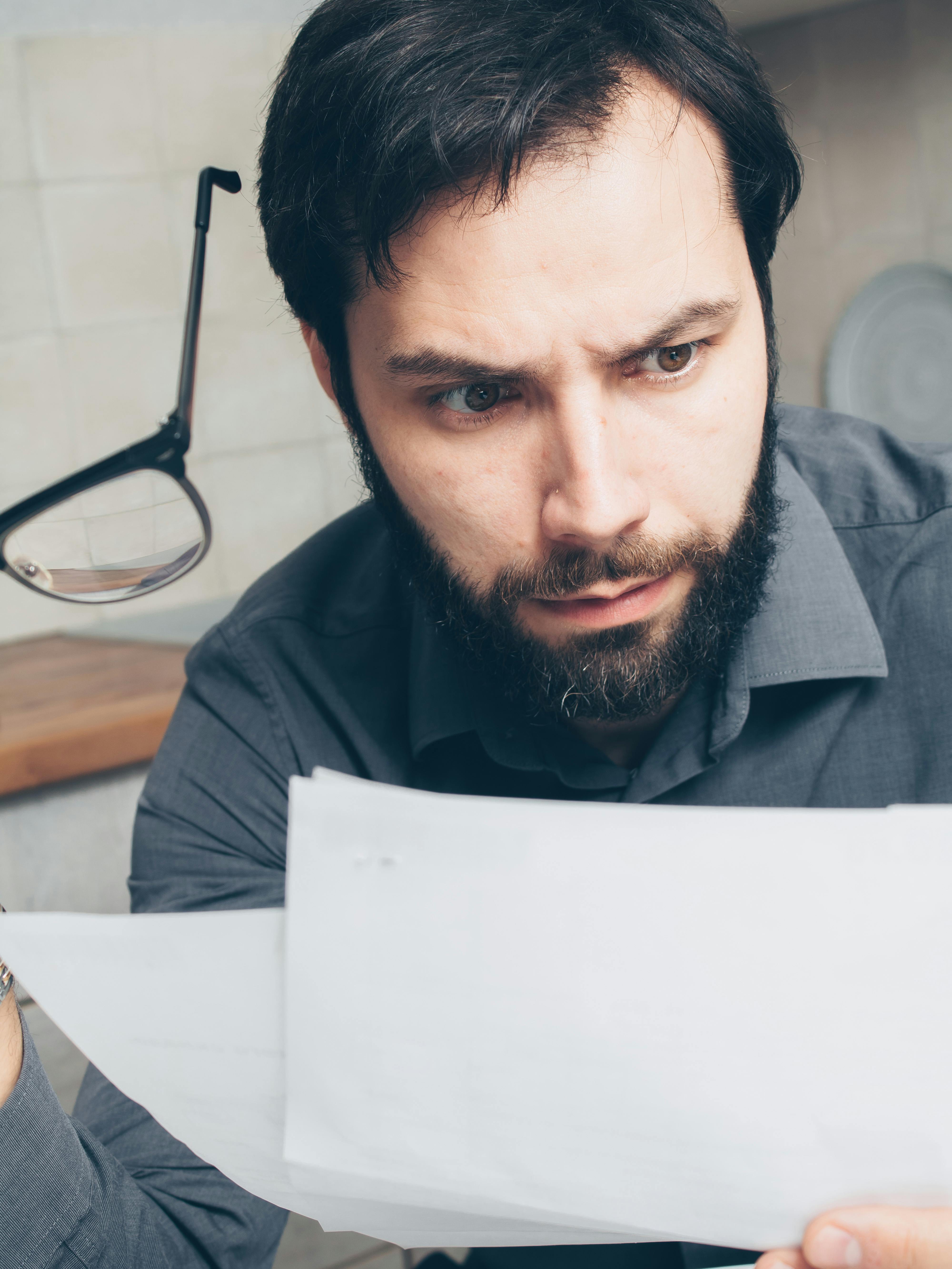 Un hombre sorprendido leyendo una nota | Fuente: Pexels