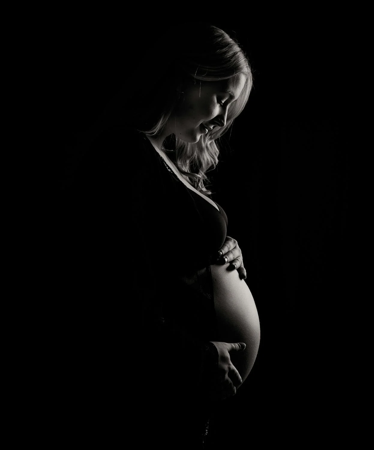 A silhouette of a pregnant woman circling her baby bump | Source: Pexels