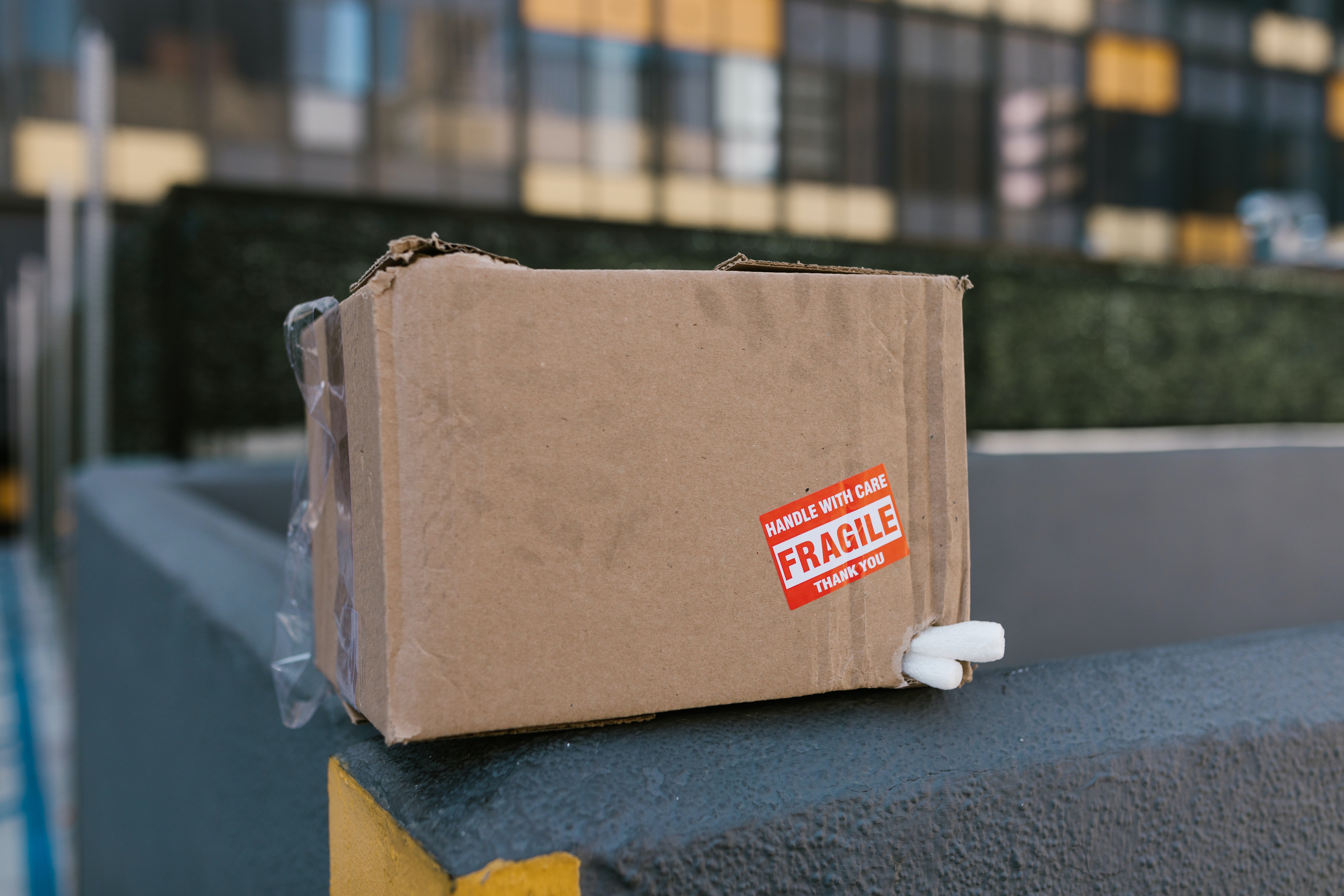 Cardboard box on top of a concrete fence. | Source: Pexels