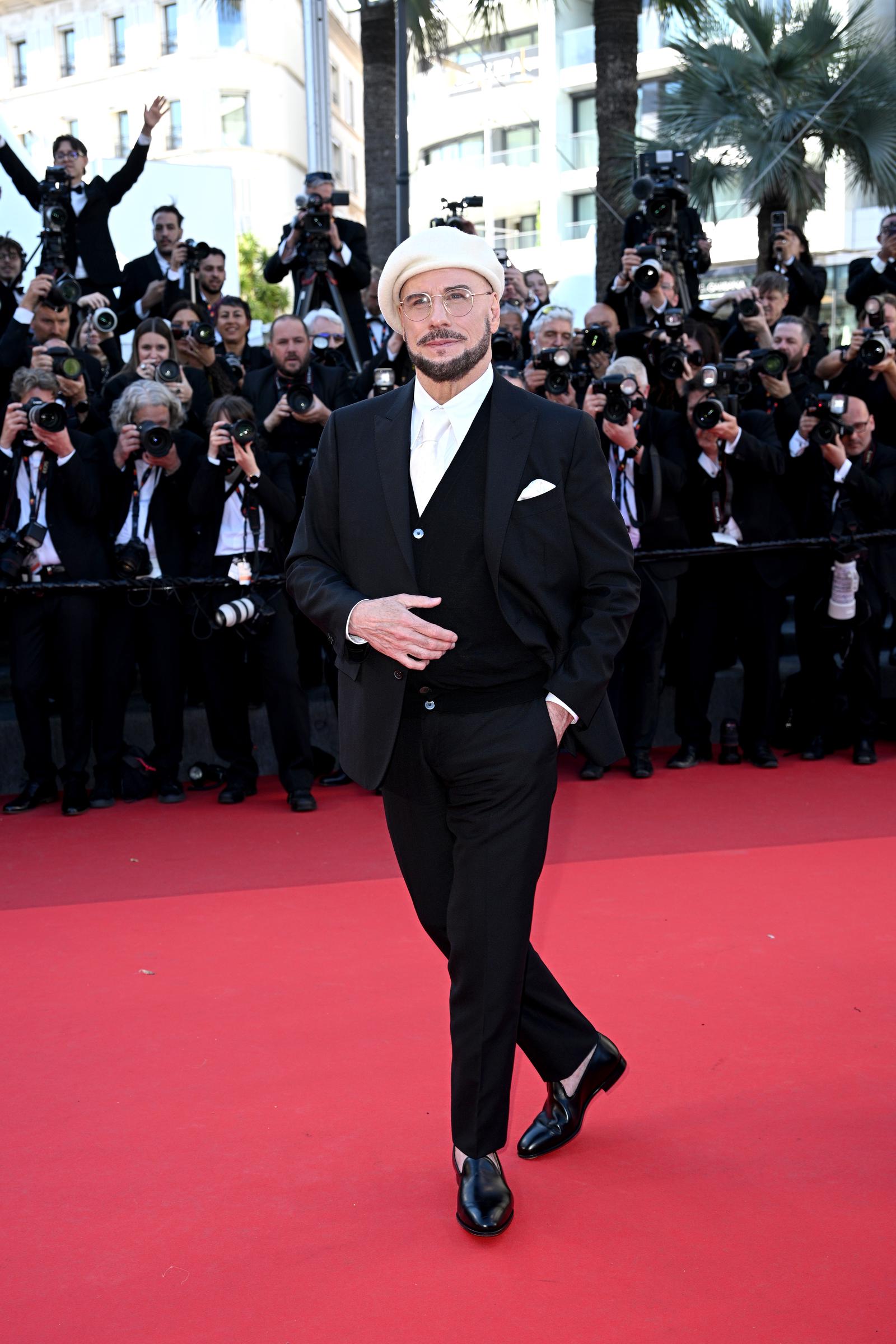John Travolta poses on the red carpet during the "Karma" screening at Palais des Festivals | Source: Getty Images