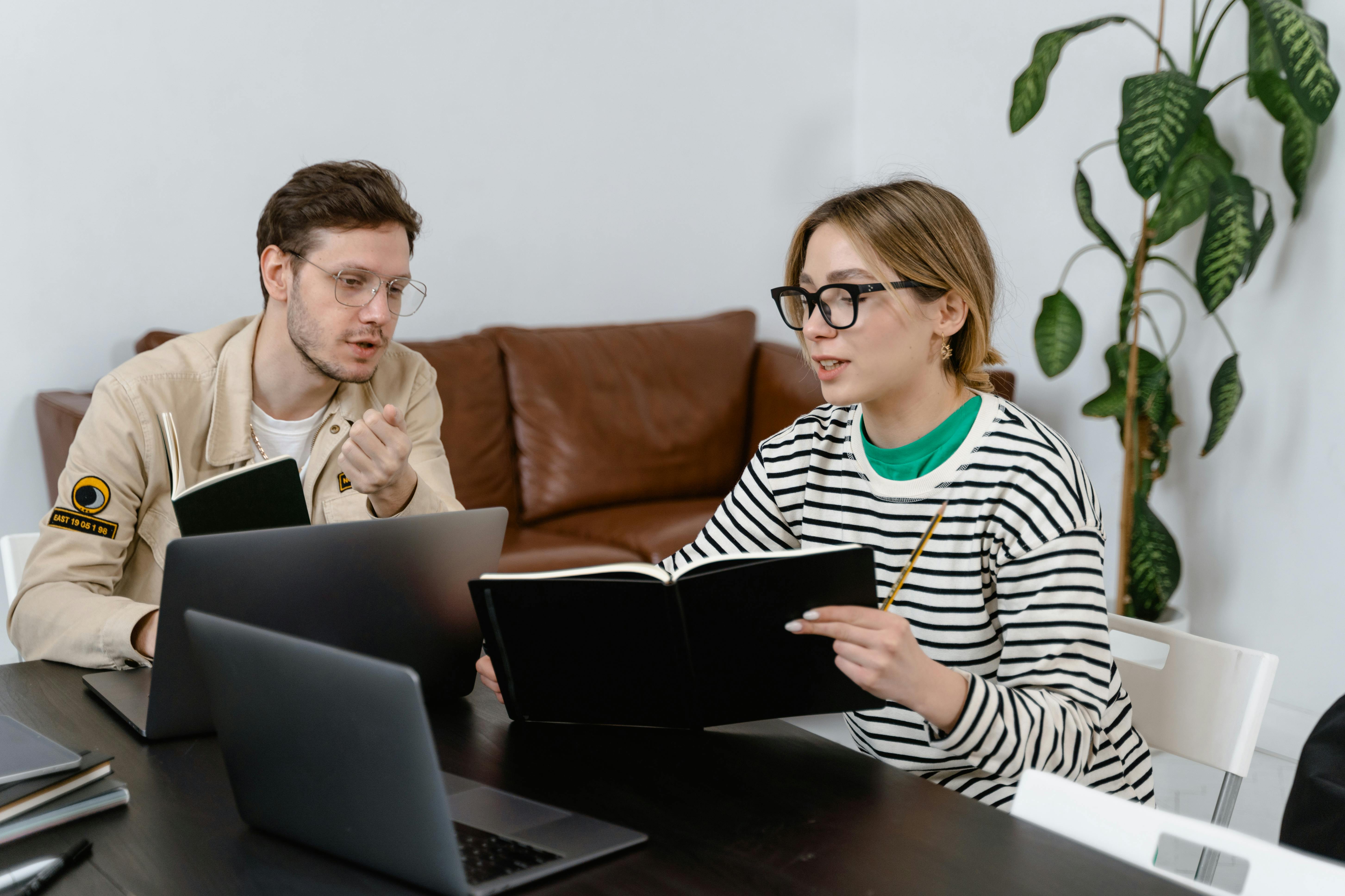 A man and a woman discussing at their workplace | Source: Pexels