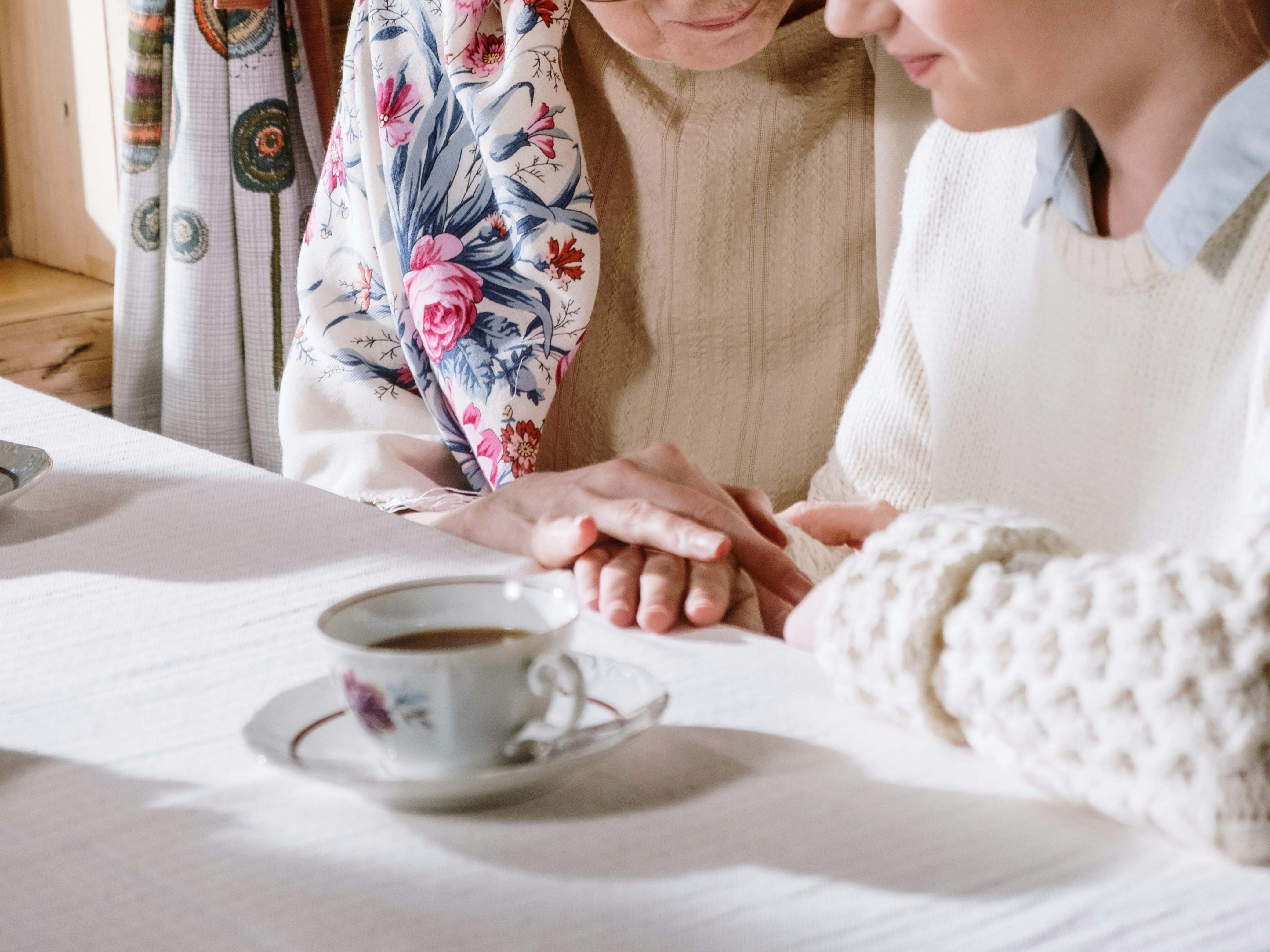 An elderly woman holding the hands of a younger companion | Source: Pexels