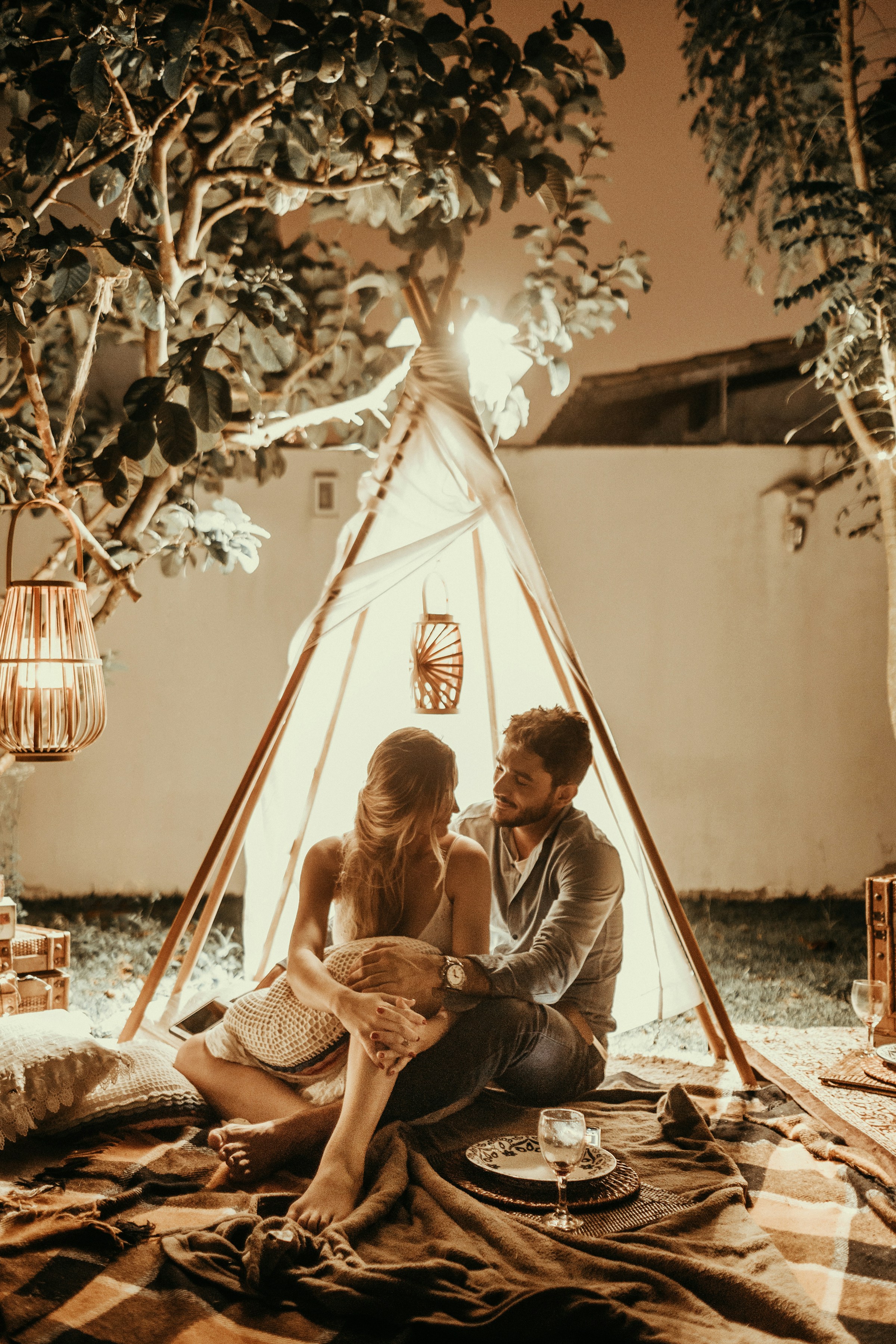 A couple sitting inside a tepee hut with lights | Source: Unsplash