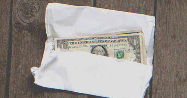 Several $1 bills in an envelope | Source: Shutterstock