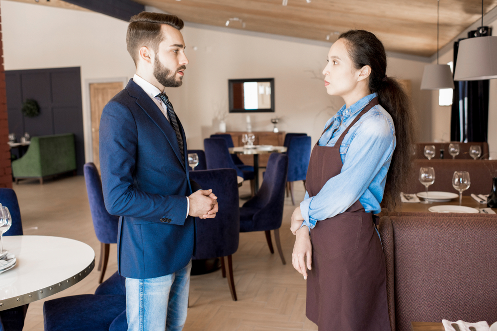A man talking to a restaurant employee | Source: Shutterstock