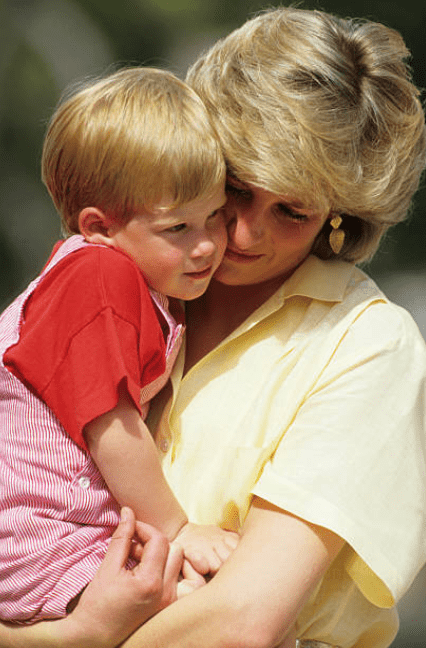  During a family holiday Princess Diana holds Prince Harry in her arms as he rests his head on her cheek, in Majorca, Spain on August 10, 1987 | Source: Georges De Keerle/Getty Images