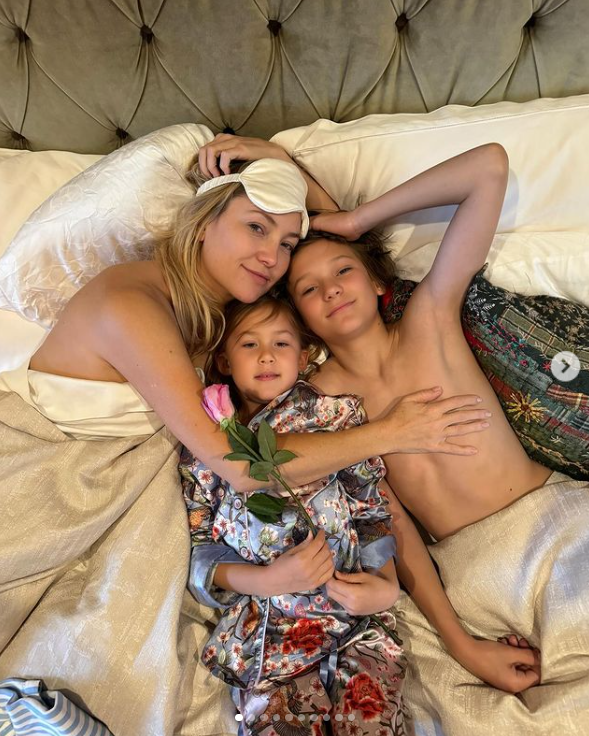 A screenshot of Kate Hudson lying in bed with her daughter, Rani Rose Fujikawa, and son, Bingham Hawn Bellamy. | Source: Instagram/katehudson