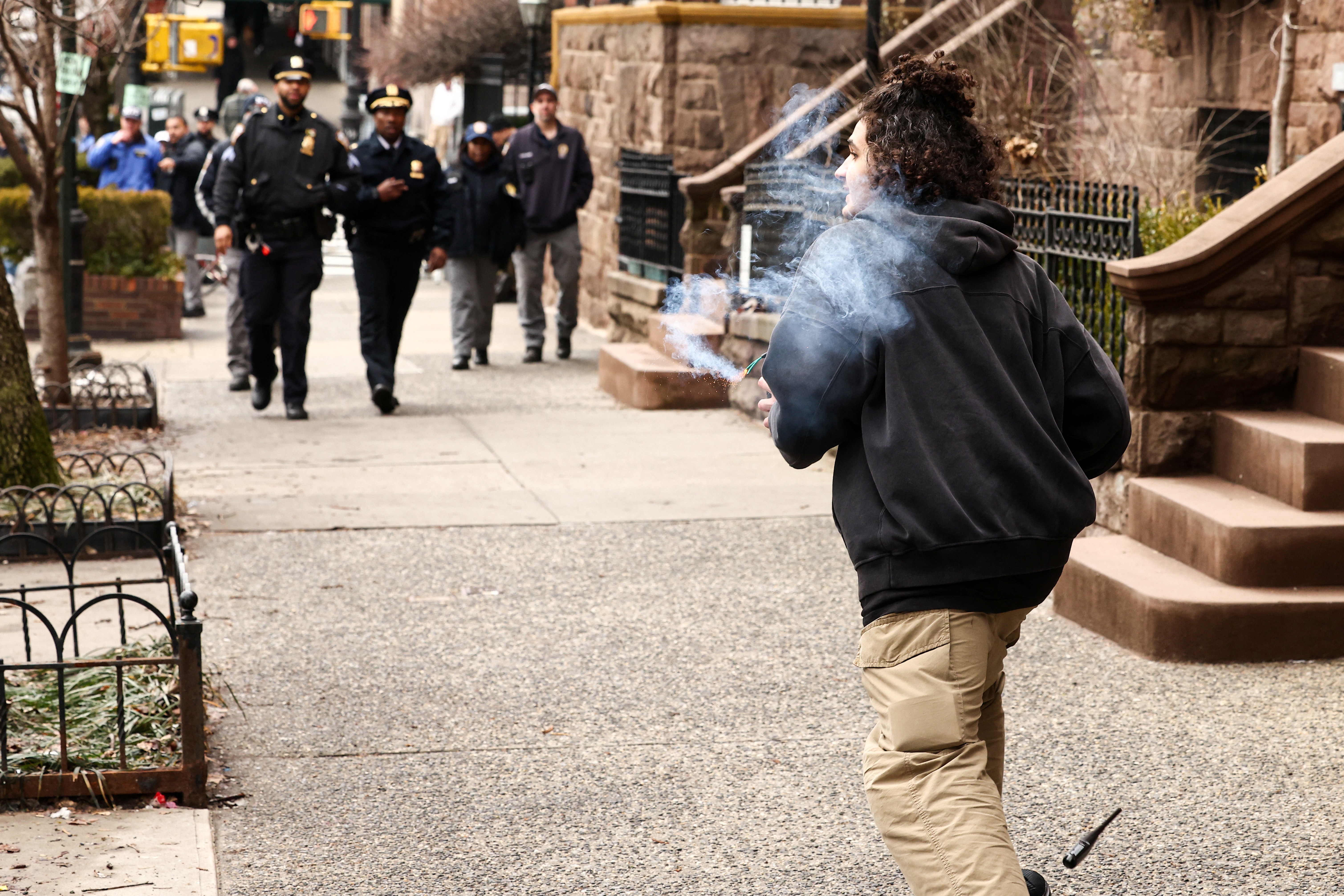 One of the suspects running with an explosive device as police approach during the protest. | Source: Getty Images