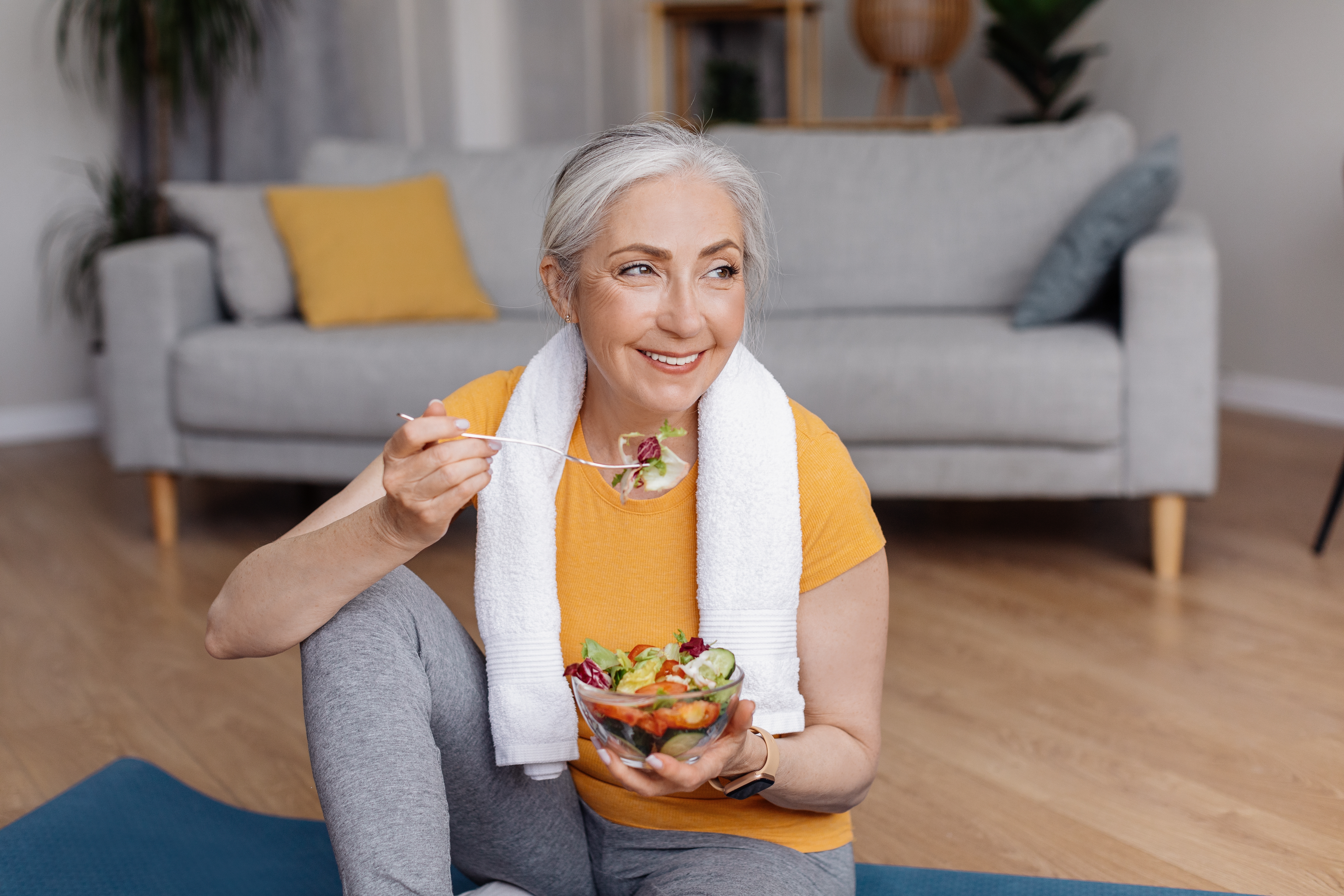 A happy senior woman eating fresh vegetable salad | Source: Shutterstock