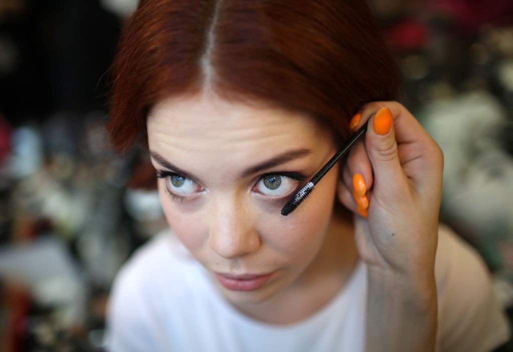 Une femme en train de se maquiller. ǀ Source : Getty Images
