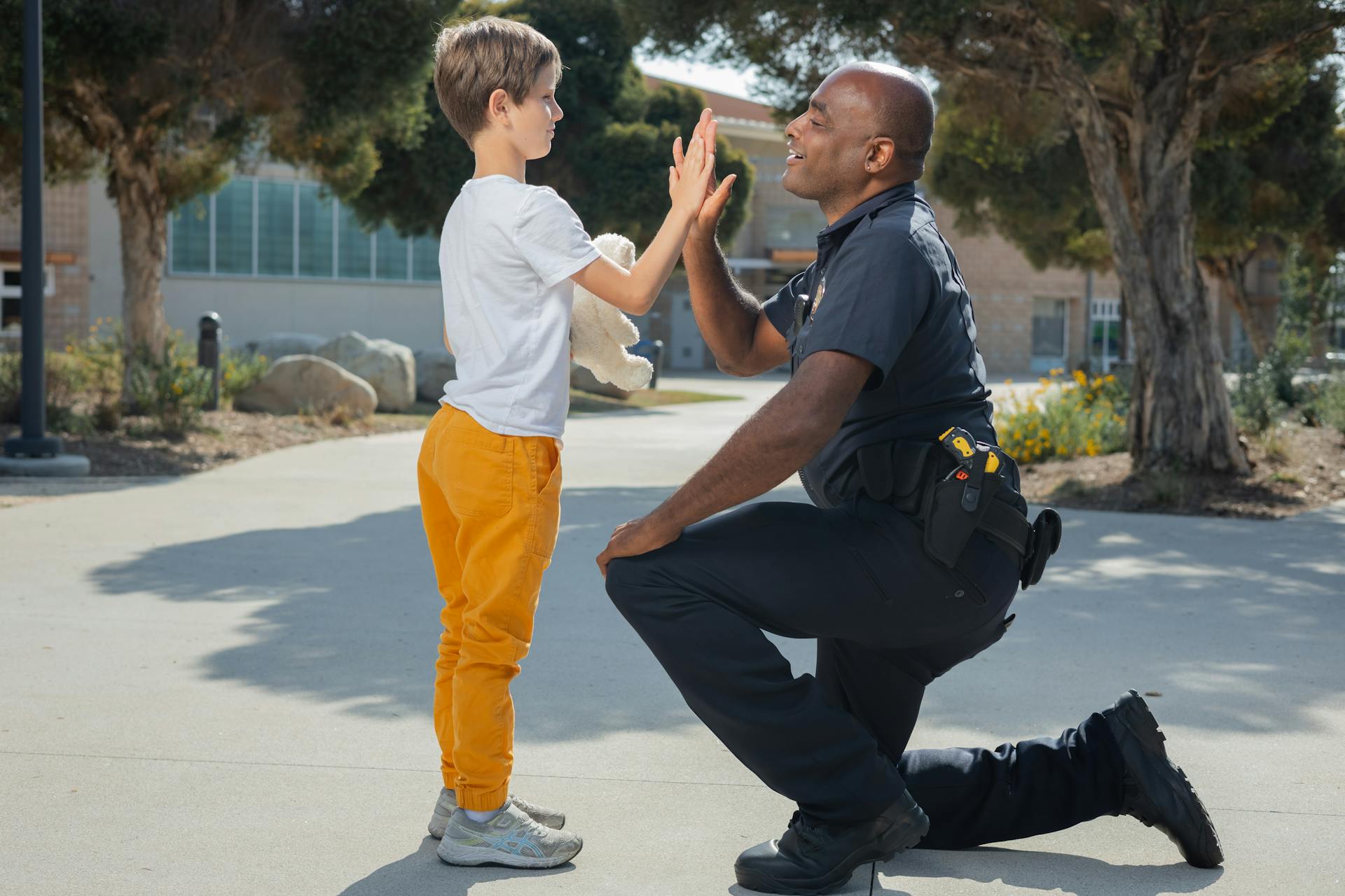 A police officer giving a high-five to a boy | Source: Pexels