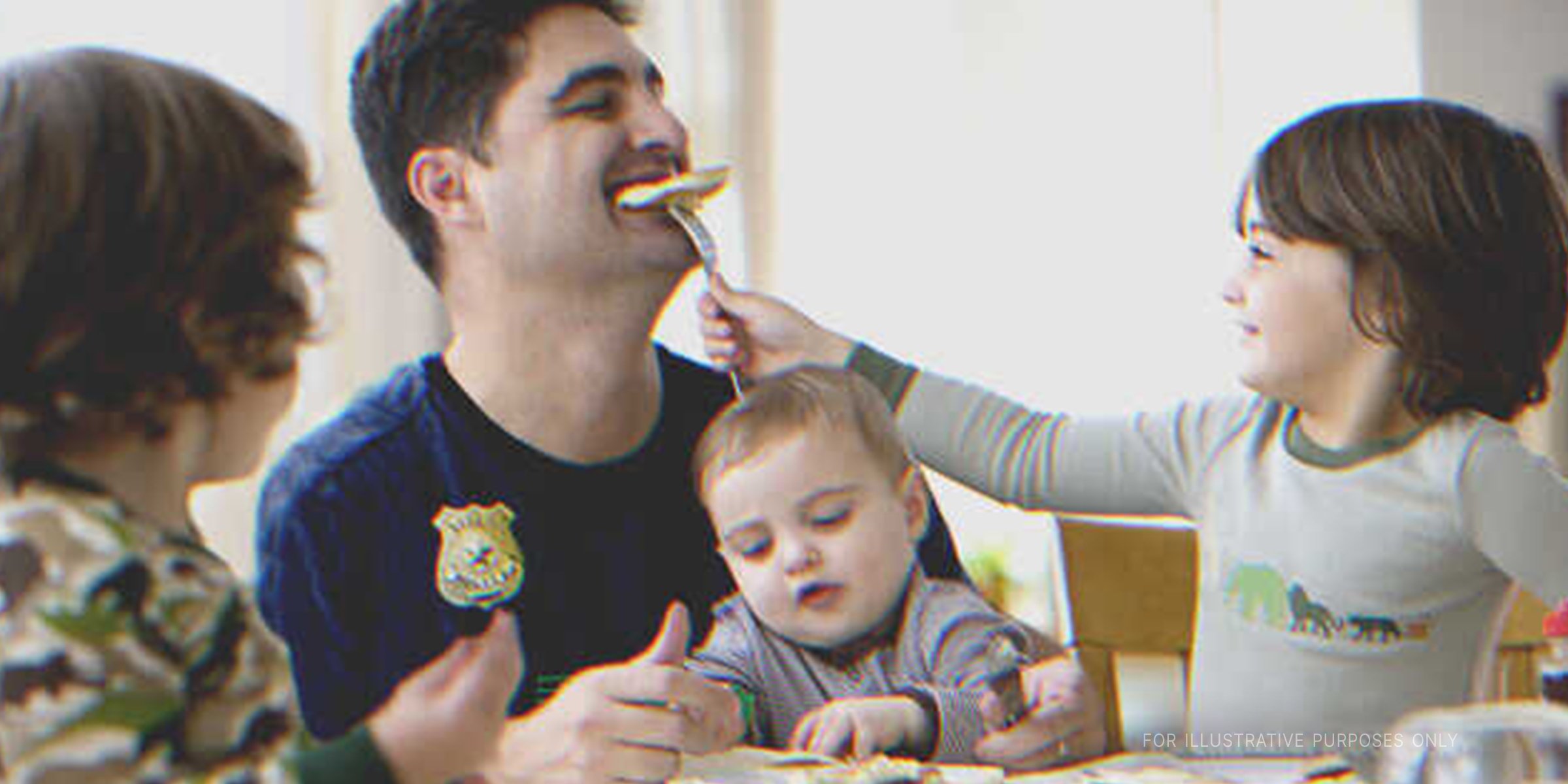Man eating with three kids. | Source: Shutterstock | Getty Images