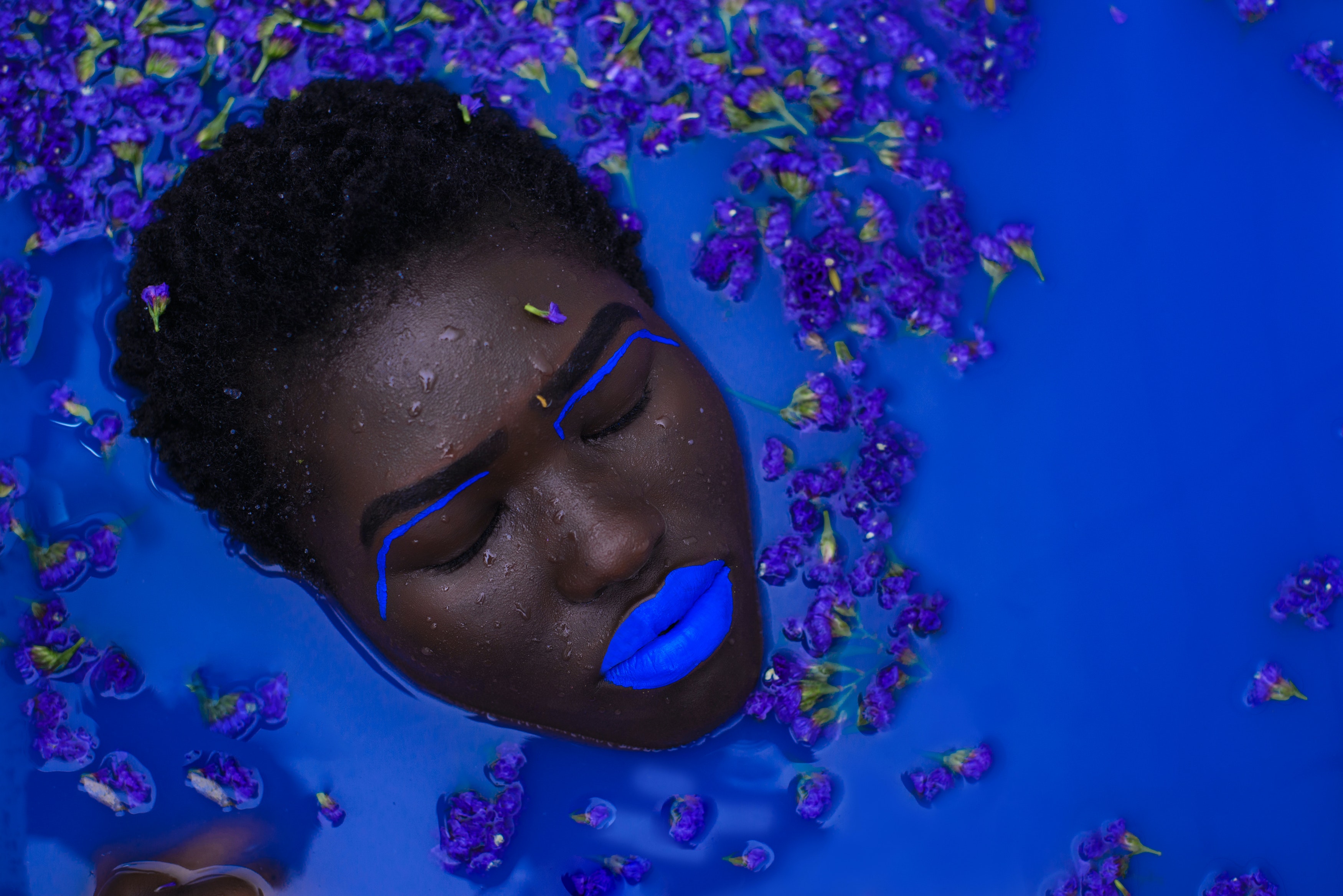 A woman bathing in blue liquid. │ Source: Pexels
