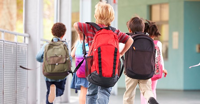 A couple of kids walking down a hallway | Photo: shutterstock.com