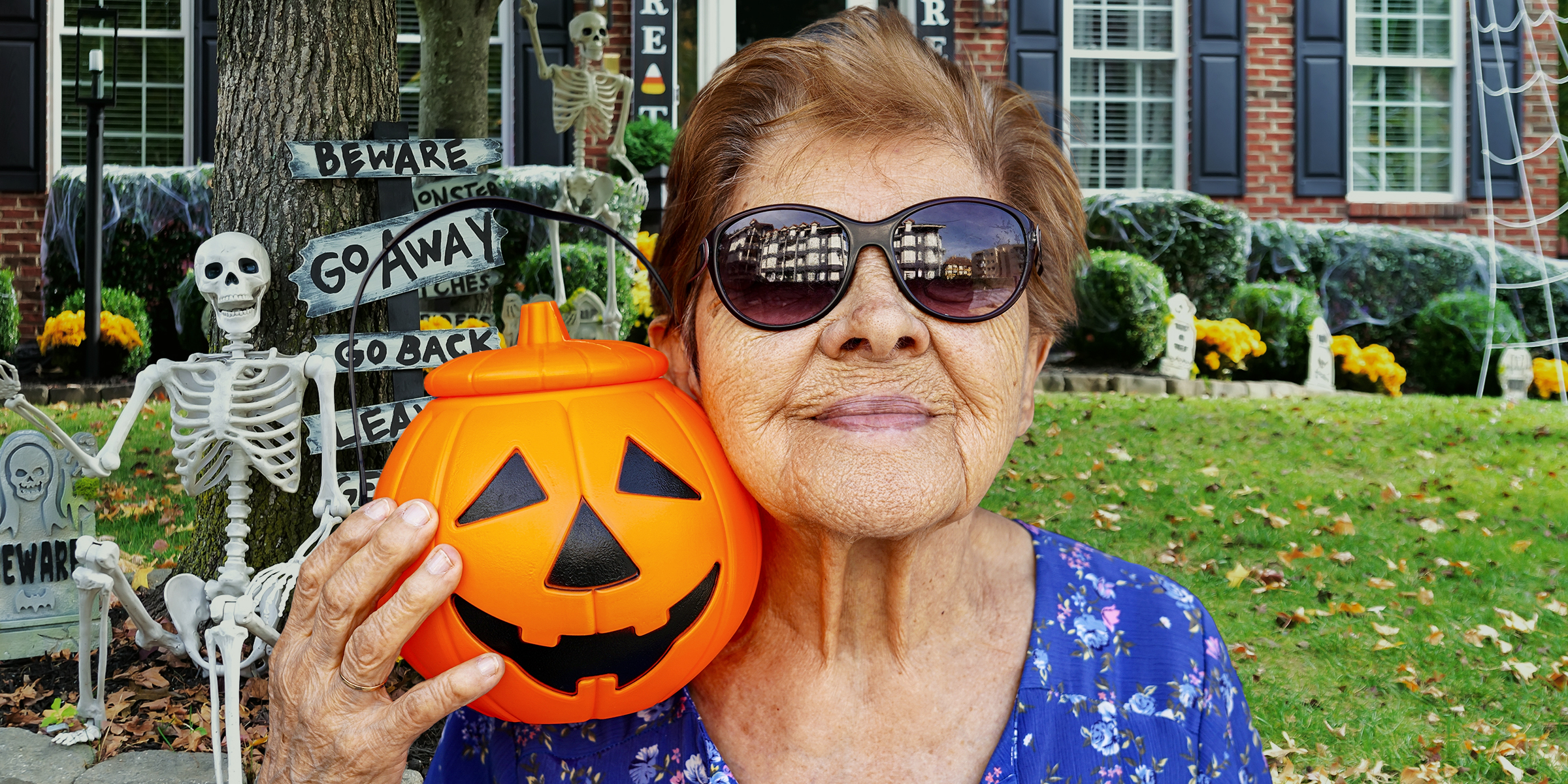 An older woman holding a Jack-o'-lantern | Source: Shutterstock