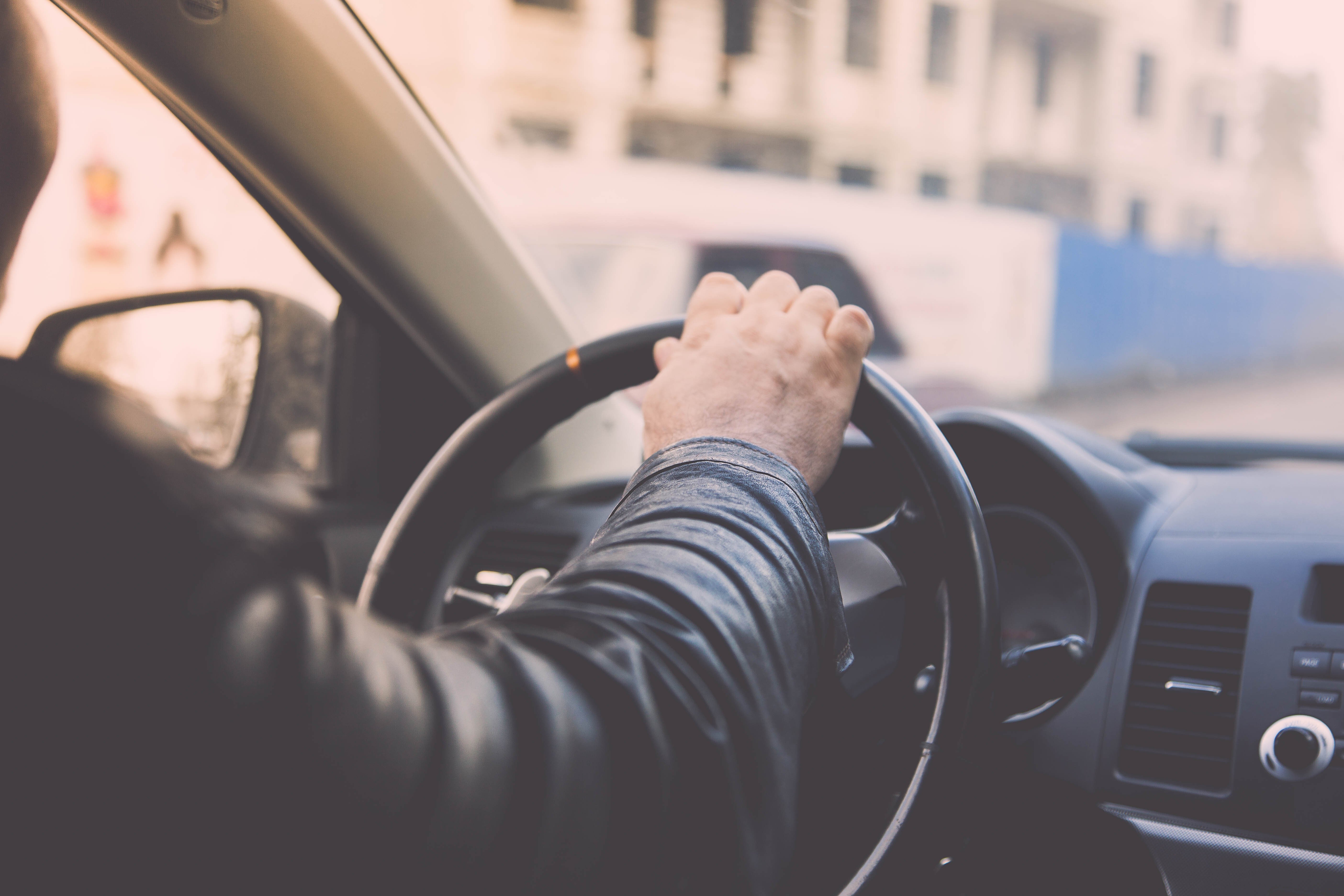 Taxi driver driving car, hand on steering wheel, looking at the road | Photo: Shutterstock.com