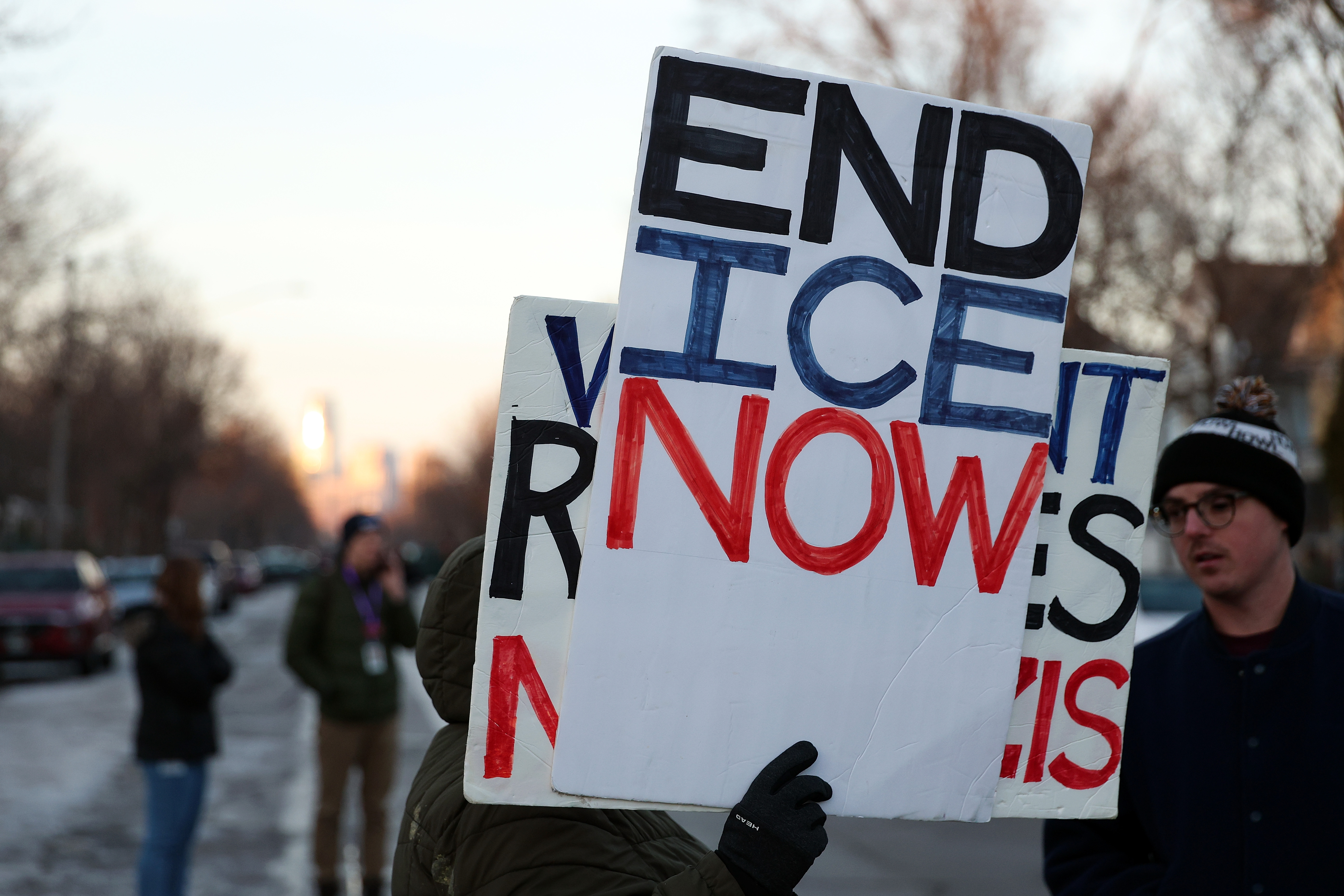 A demonstrator holds a sign during a vigil following a shooting by an ICE agent during federal law enforcement operations in Minneapolis, Minnesota  on January 7, 2026. | Source: Getty Images