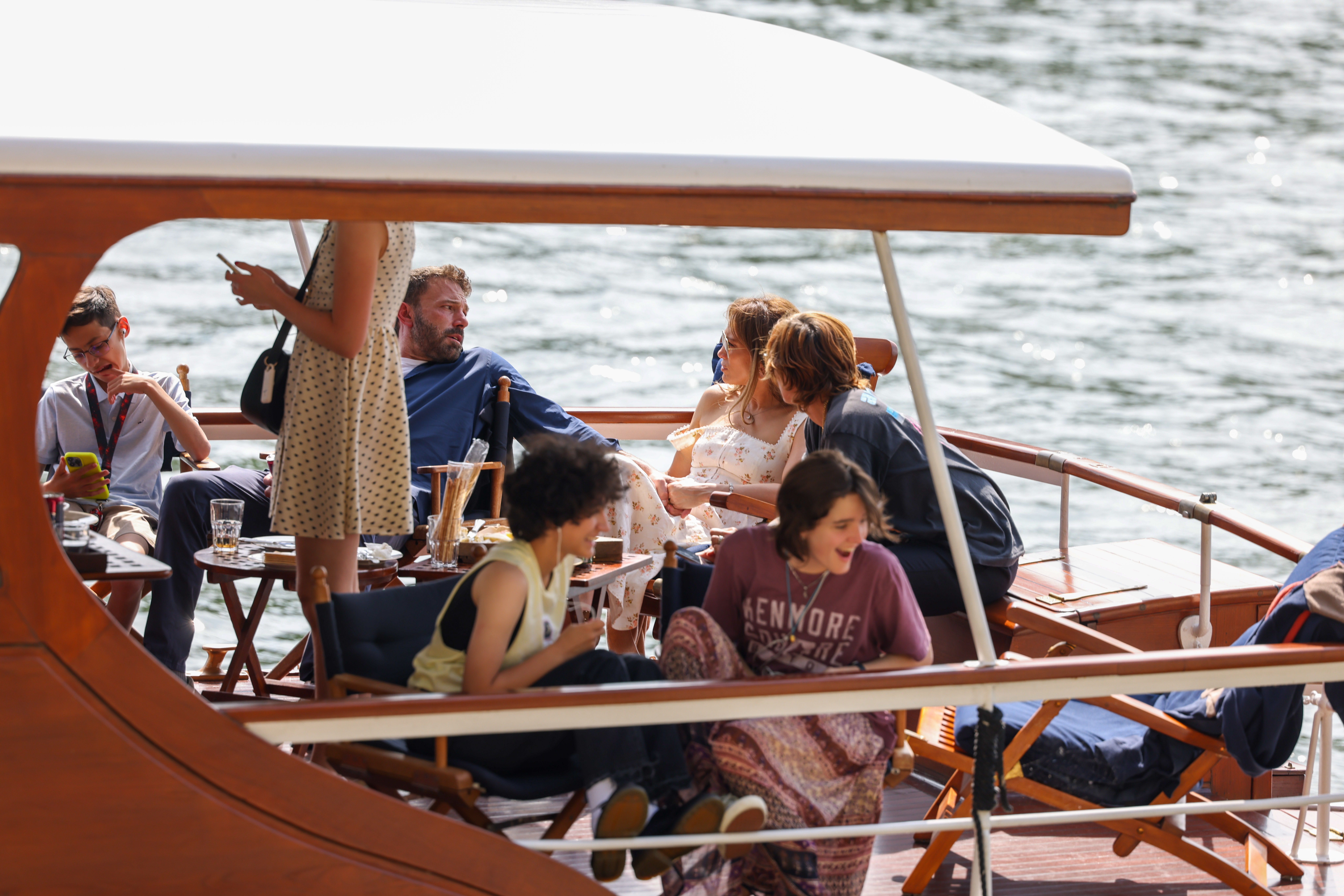 Jennifer Lopez and Ben Affleck take a cruise on the River Seine along with some of their children, Seraphina Affleck (front R) and Emme Muniz (front L) on July 23, 2022, in Paris, France. | Source: Getty Images