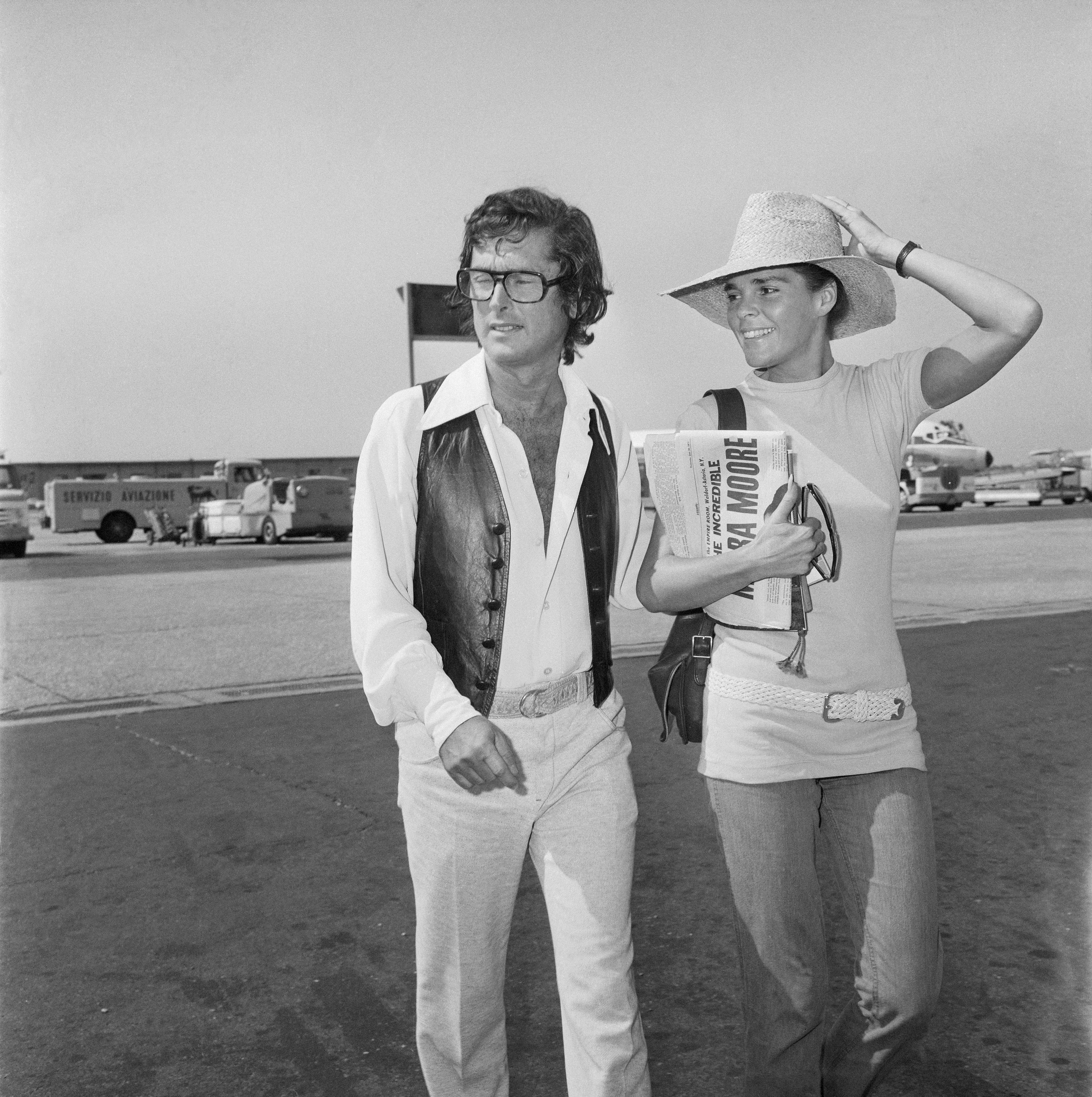 Robert Evans and Ali MacGraw arriving at an airport in Rome, 1971 | Source: Getty Images