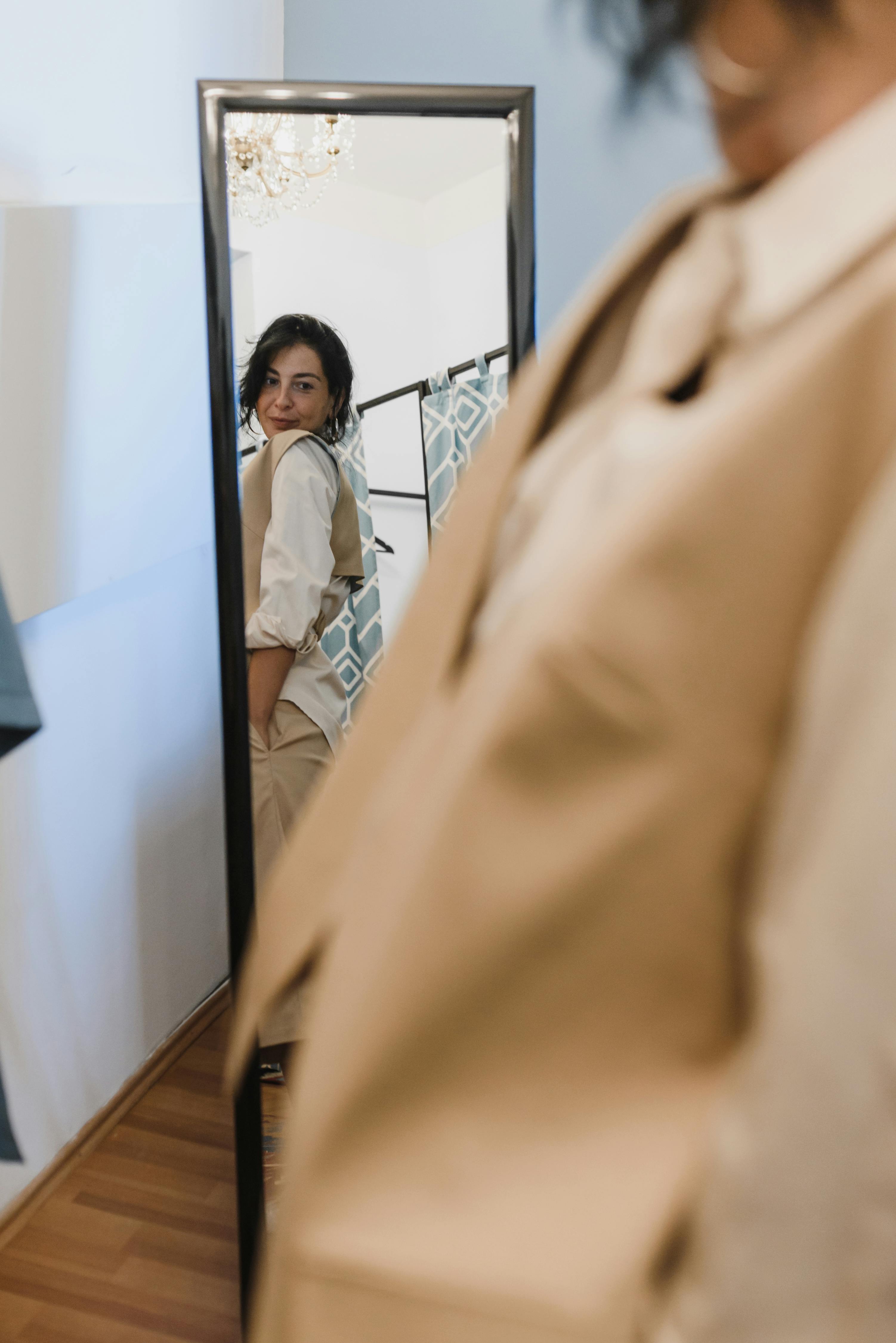 A woman checks her outfit in the mirror. For illustration purposes only | Source: Pexels
