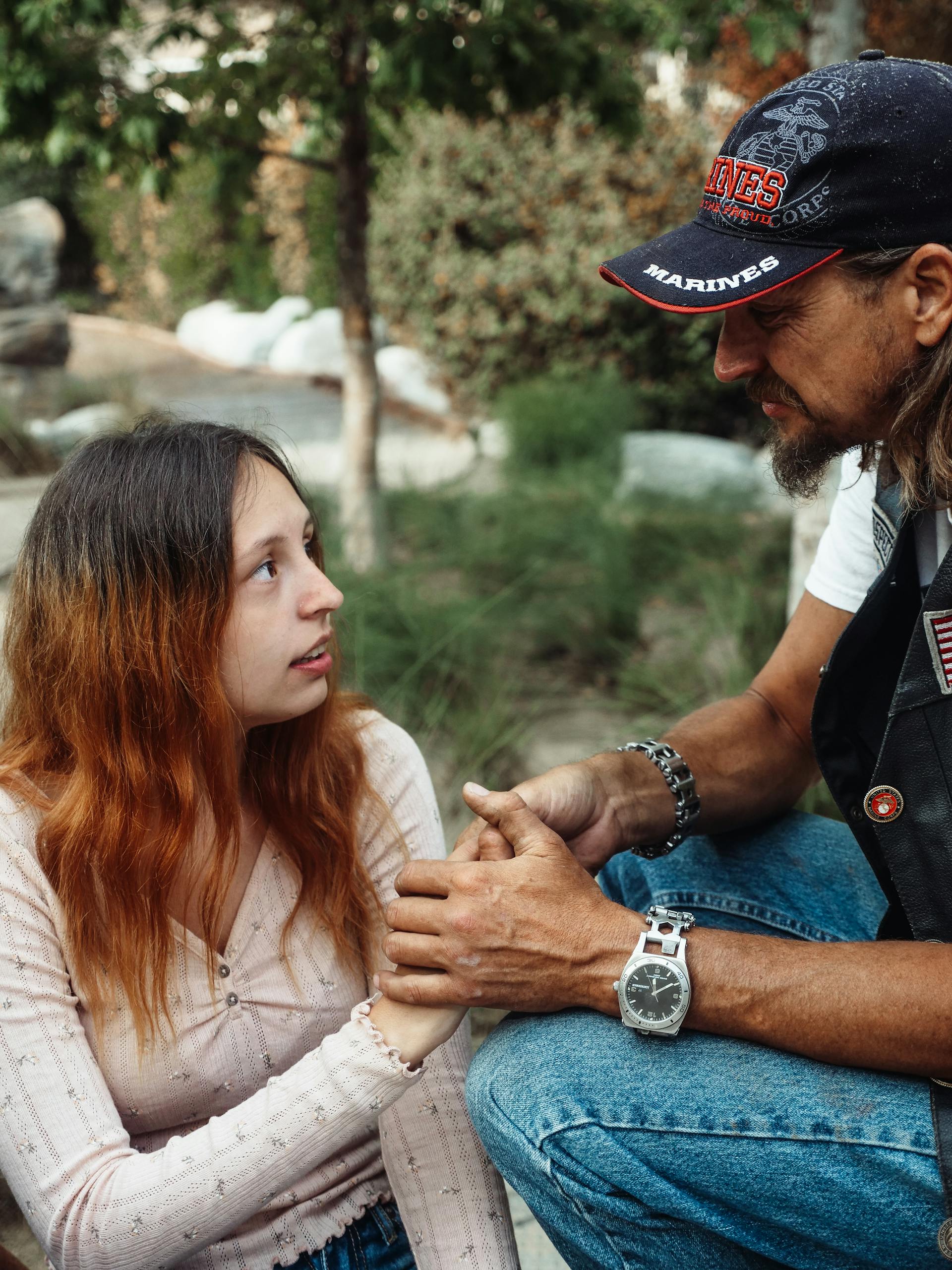 Un padre emotivo sosteniendo la mano de su hija | Fuente: Pexels