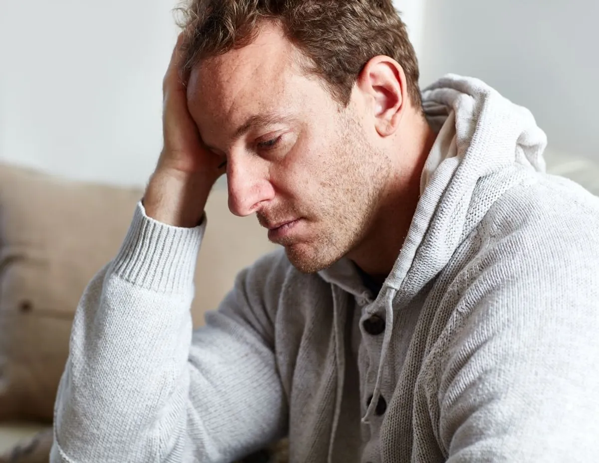 Ein Mann zu Hause sieht traurig aus. | Source: Shutterstock